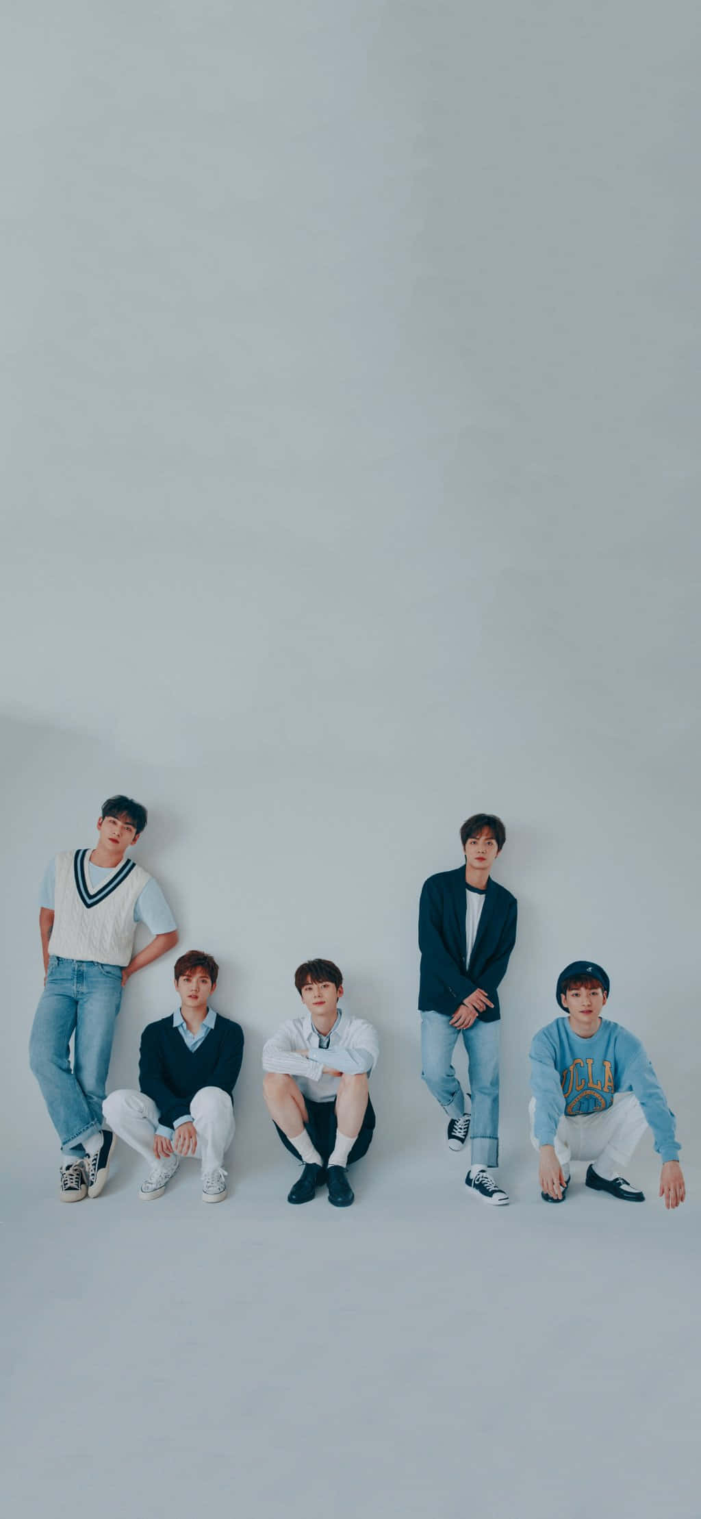 Nu'est 男子團體 — 音樂與團結的力量 壁紙 — 五位年輕男性身穿休閒服裝，在帶有柔和陰影的純淺灰色攝影棚背景前擺姿勢。