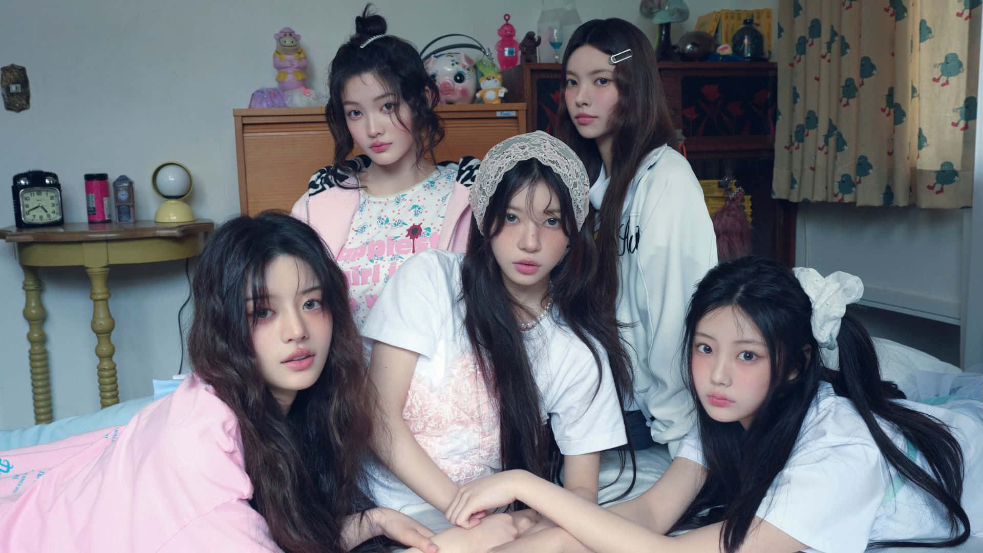 壁紙 — 五位穿著睡衣的年輕女性在一個充滿可愛裝飾和柔和燈光的舒適臥室床上一起擺姿勢。