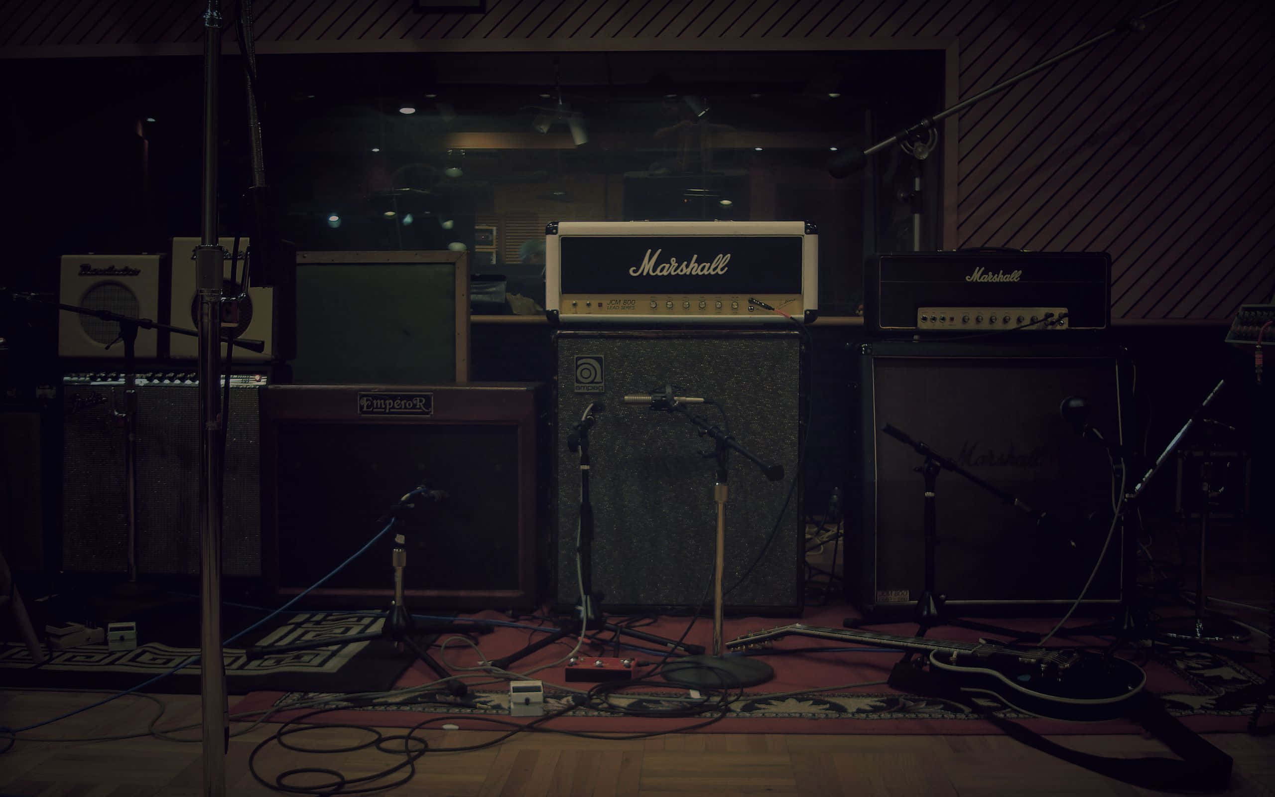 FL Studio 馬歇爾音箱 壁紙 — 燈光昏暗的錄音室，配備復古 Marshall 擴音器和咪高峰，為搖滾樂隊表演而佈置。