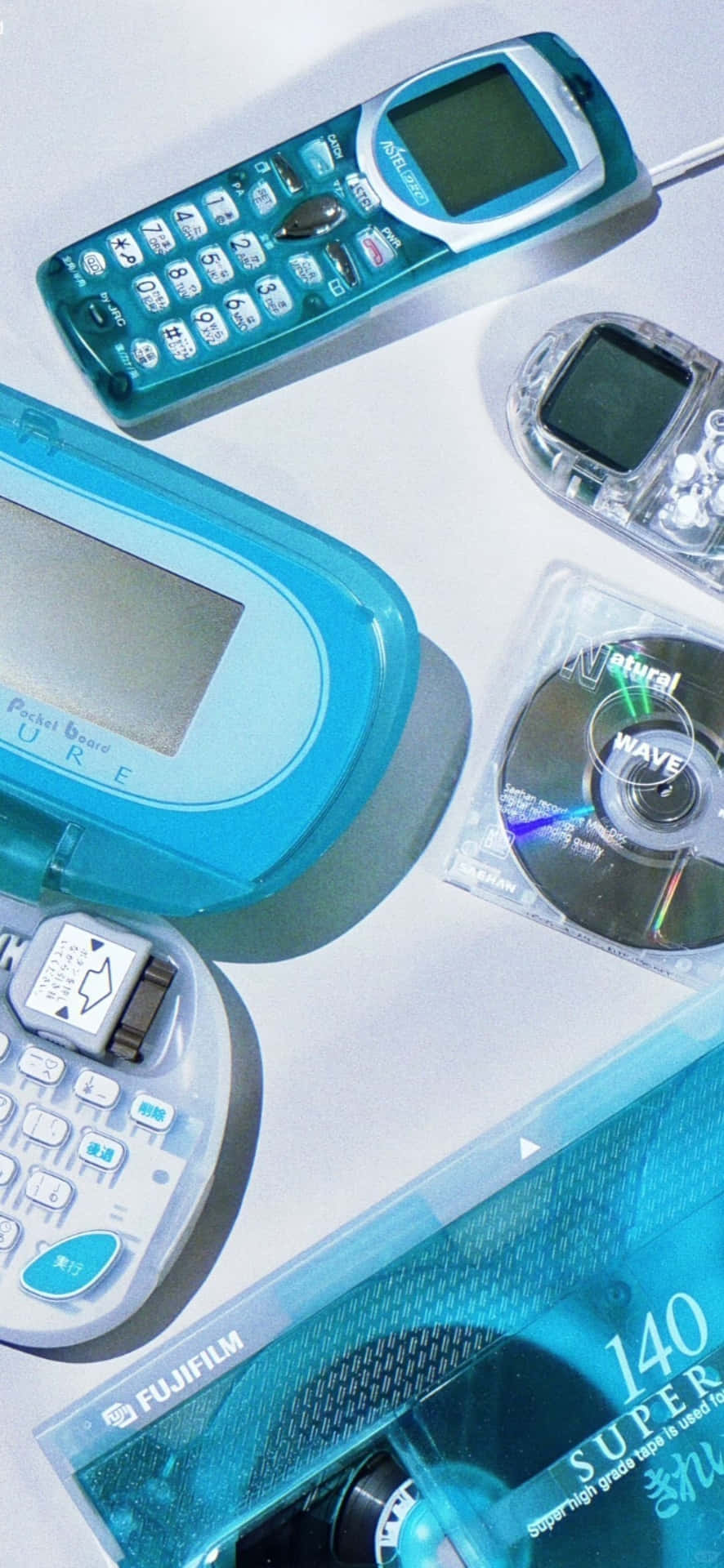  壁紙 — 復古青綠色和銀色科技小工具（包括電話、相機和CD）的平鋪佈局，沐浴在冷光中。