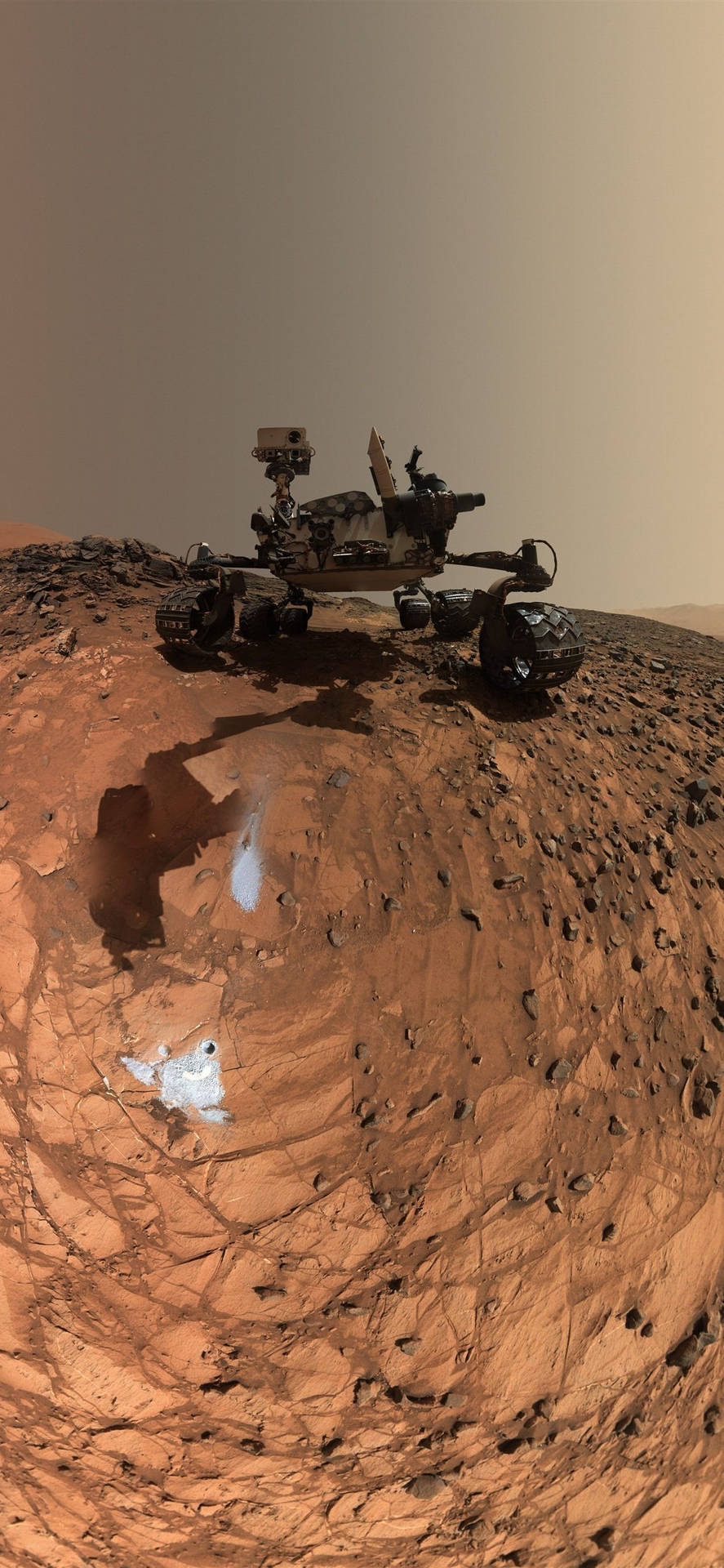 火星探測車探索帶有冰塊的紅色岩石地形。