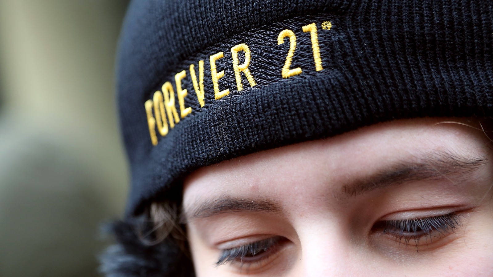 Forever 21 Beanie Cap 壁紙 — 一個人戴住黑色冷帽，帽上有金色刺繡字樣 forever 21 嘅特寫。