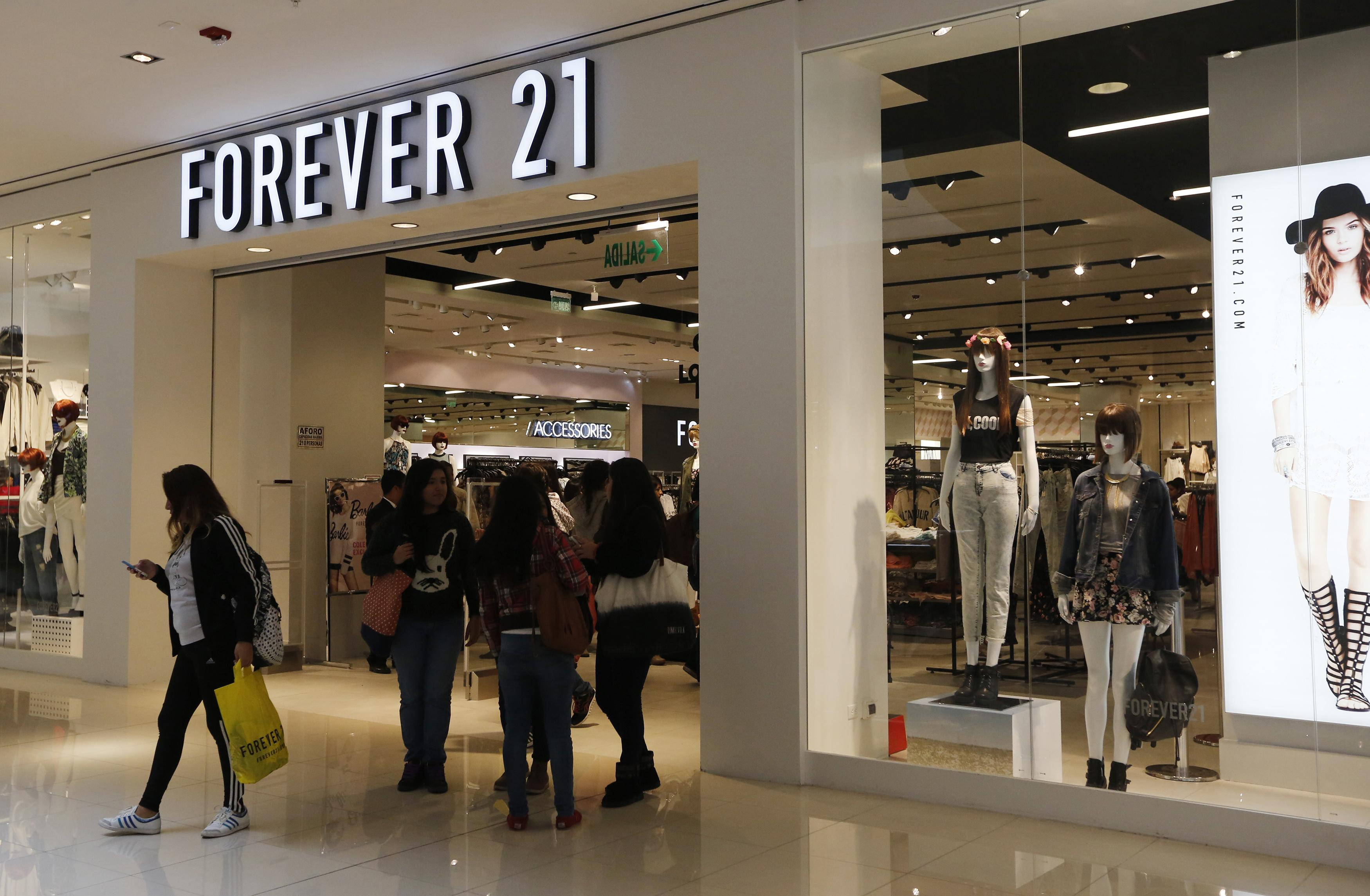 Forever 21時尚店鋪 壁紙 — 購物者在光線明亮的購物中心內，在Forever 21商店外瀏覽，櫥窗內的人體模型展示著時尚服裝。