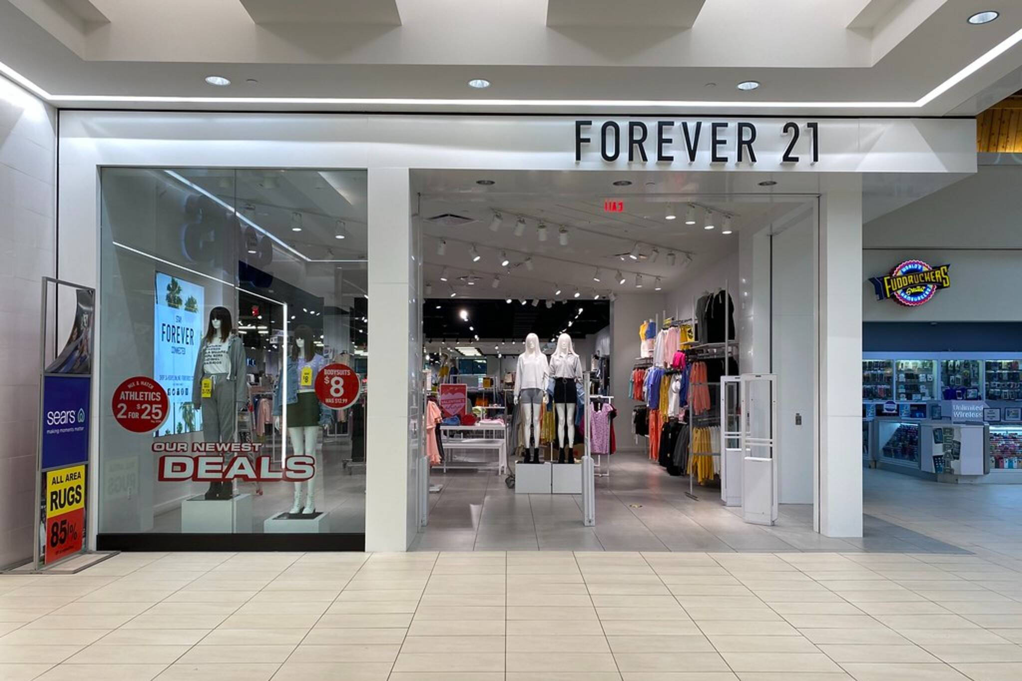 Forever 21精品店 壁紙 — 購物中心內一間燈光明亮的Forever 21商店入口，人體模型展示服裝和促銷優惠標誌。
