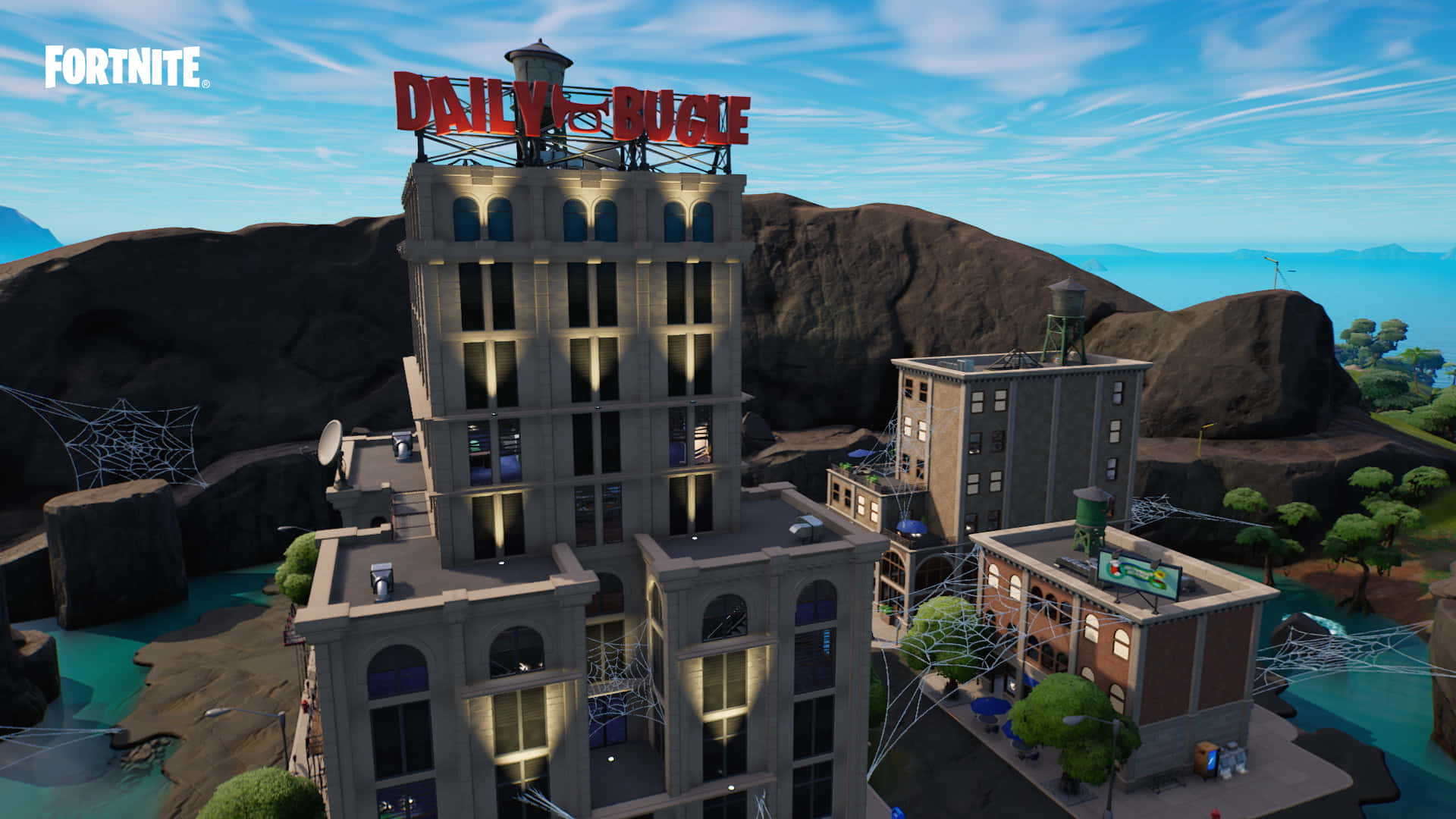 Fortnite Chapter 3 桌布 壁紙 — Fortnite 中高聳的號角日報大樓矗立在岩石地形中，發光的窗戶和蜘蛛網在明亮的藍天下。