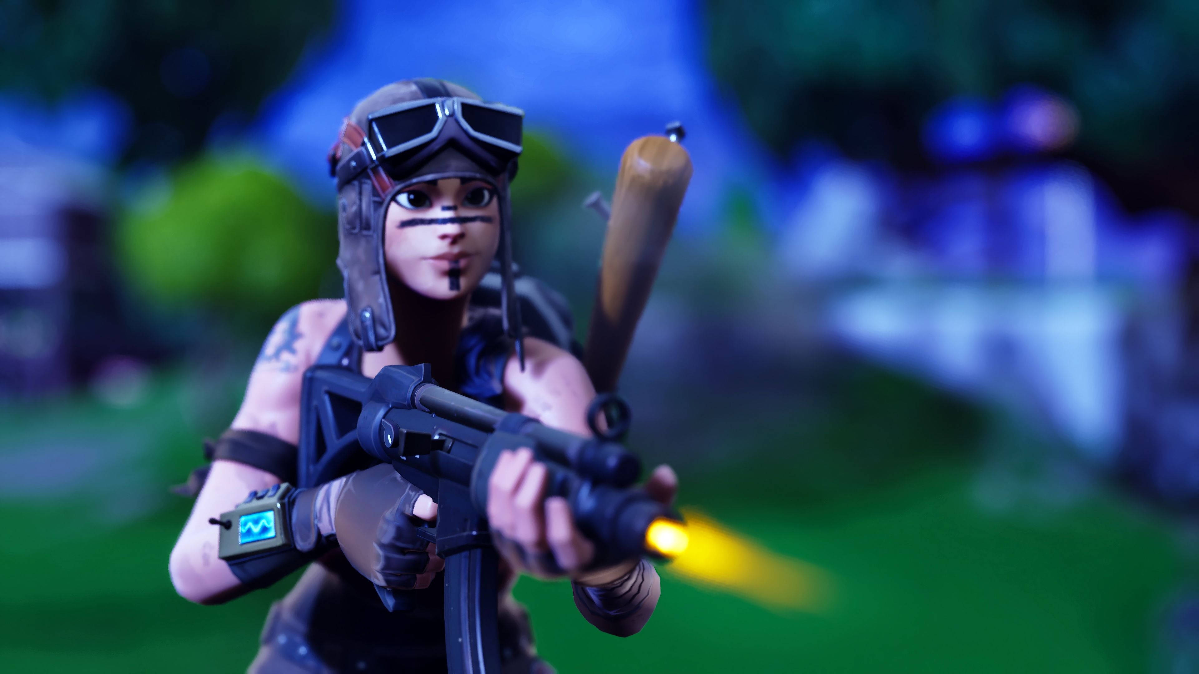 《Fortnite》叛逆掠奪者執行任務 壁紙 — 一個戴護目鏡和臉部彩繪的 Fortnite 角色在模糊的戶外環境中發射發光武器。