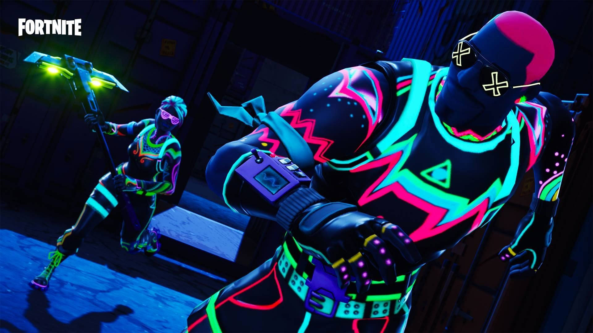 兩個身穿發光霓虹裝備的Fortnite角色在黑暗的倉庫中擺姿勢。