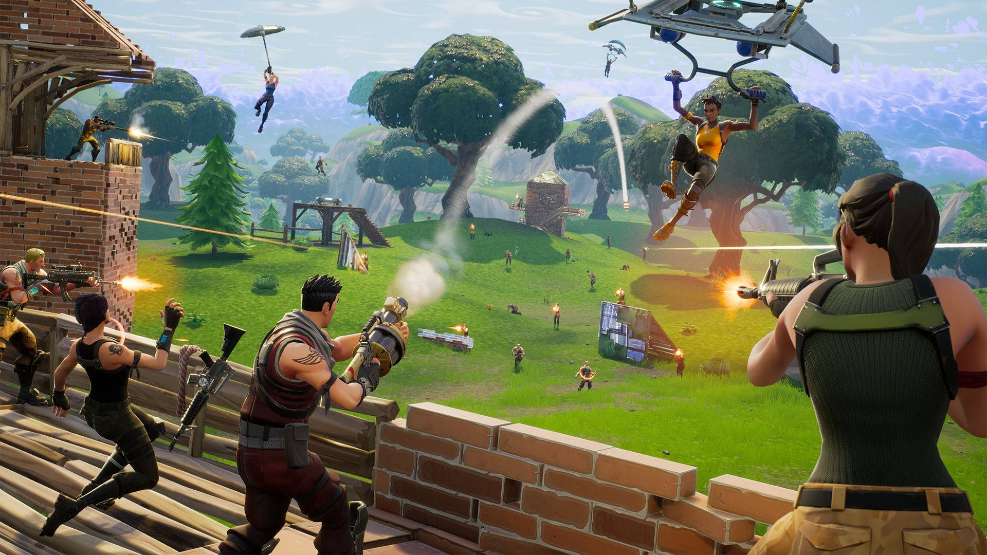 《Fortnite 競技場》壯闊戰鬥 壁紙 — 玩家在一個有樹木和磚結構的草島上戰鬥，滑翔機在頭頂翱翔，構成充滿活力的Fortnite場景。
