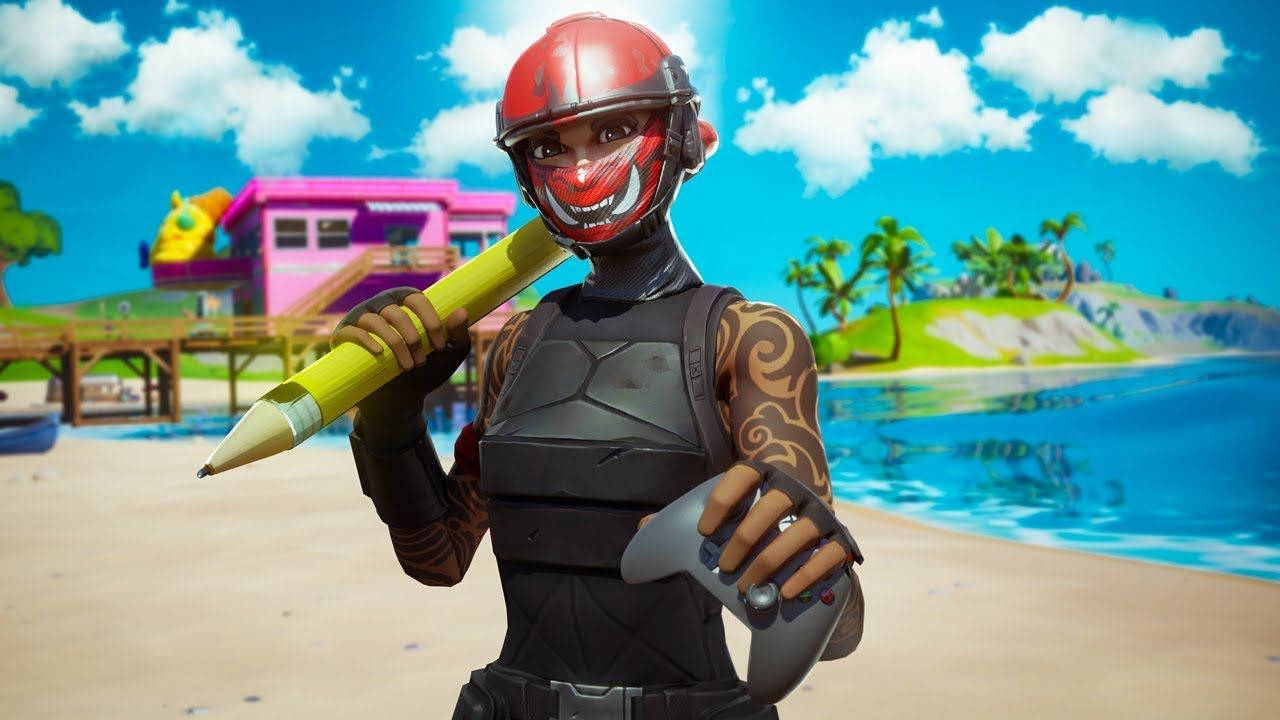 Fortnite 精選縮圖：Ramirez 身著 Manic 無面罩裝束於海灘 壁紙 — 一個戴紅色頭盔、穿黑色盔甲的Fortnite角色，在陽光明媚的海灘上，手持巨型黃色鉛筆和遊戲控制器，背景是色彩繽紛的建築物和棕櫚樹。