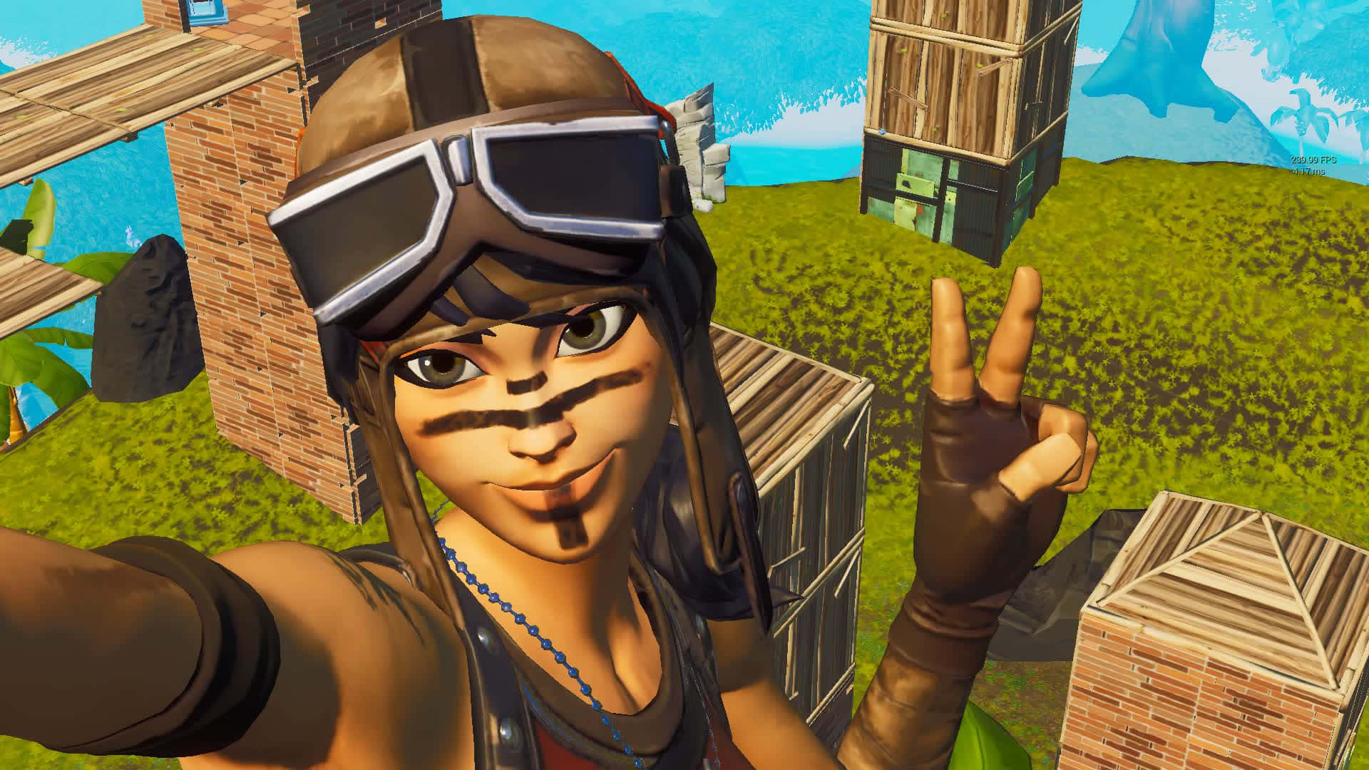 Fortnite角色比和平手勢的搞笑圖片 壁紙 — 一個身穿飛行員裝備的開心動畫角色在明亮的方塊遊戲世界中微笑並比出和平手勢。