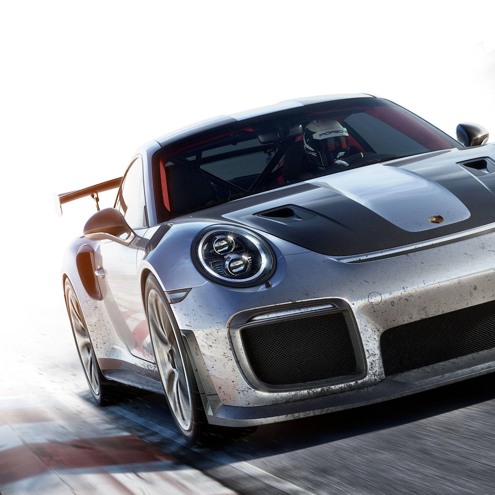 銀色保時捷911 GT2 RS賽車在賽道上飛馳，車身有泥土濺污。
