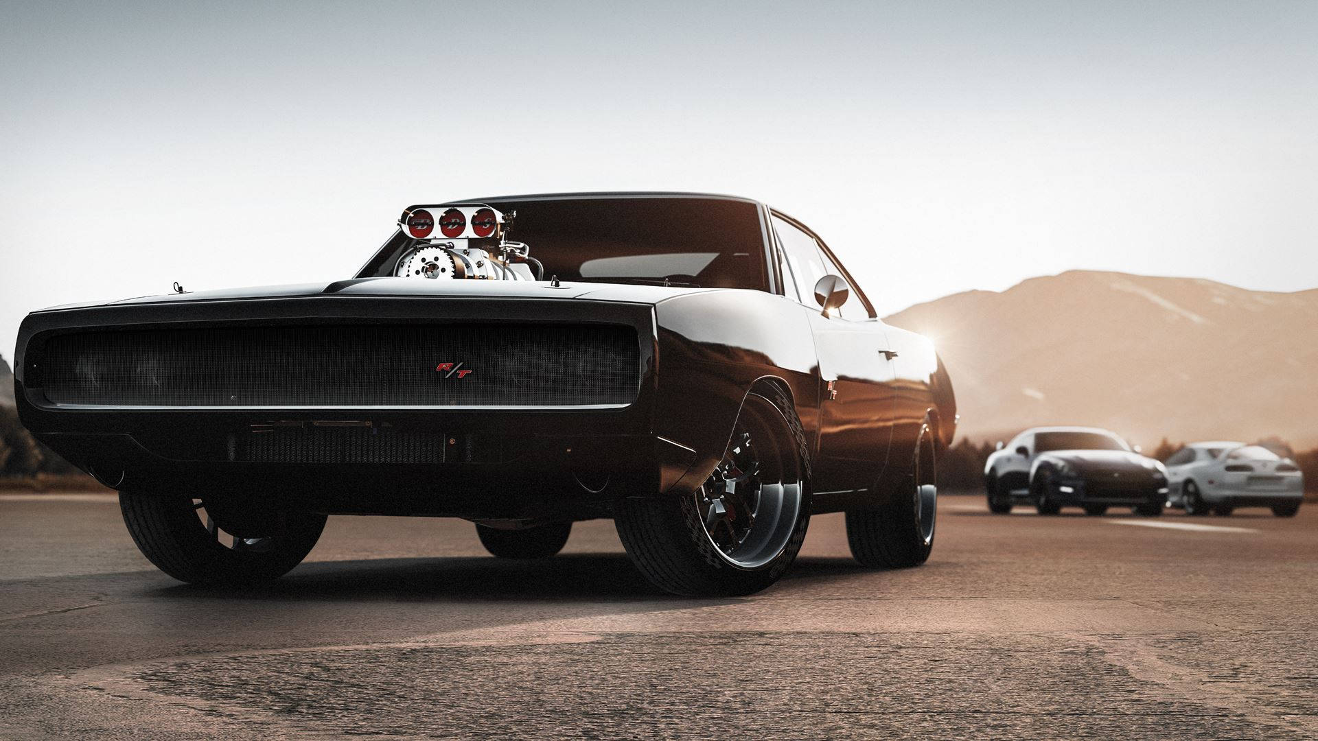 《Forza Horizon 2》日落停車場 壁紙 — 一輛黑色肌肉車，引擎外露，配備訂製輪圈，在日落時分的沙漠賽道上佔據主導地位，背景還有另外兩輛車。