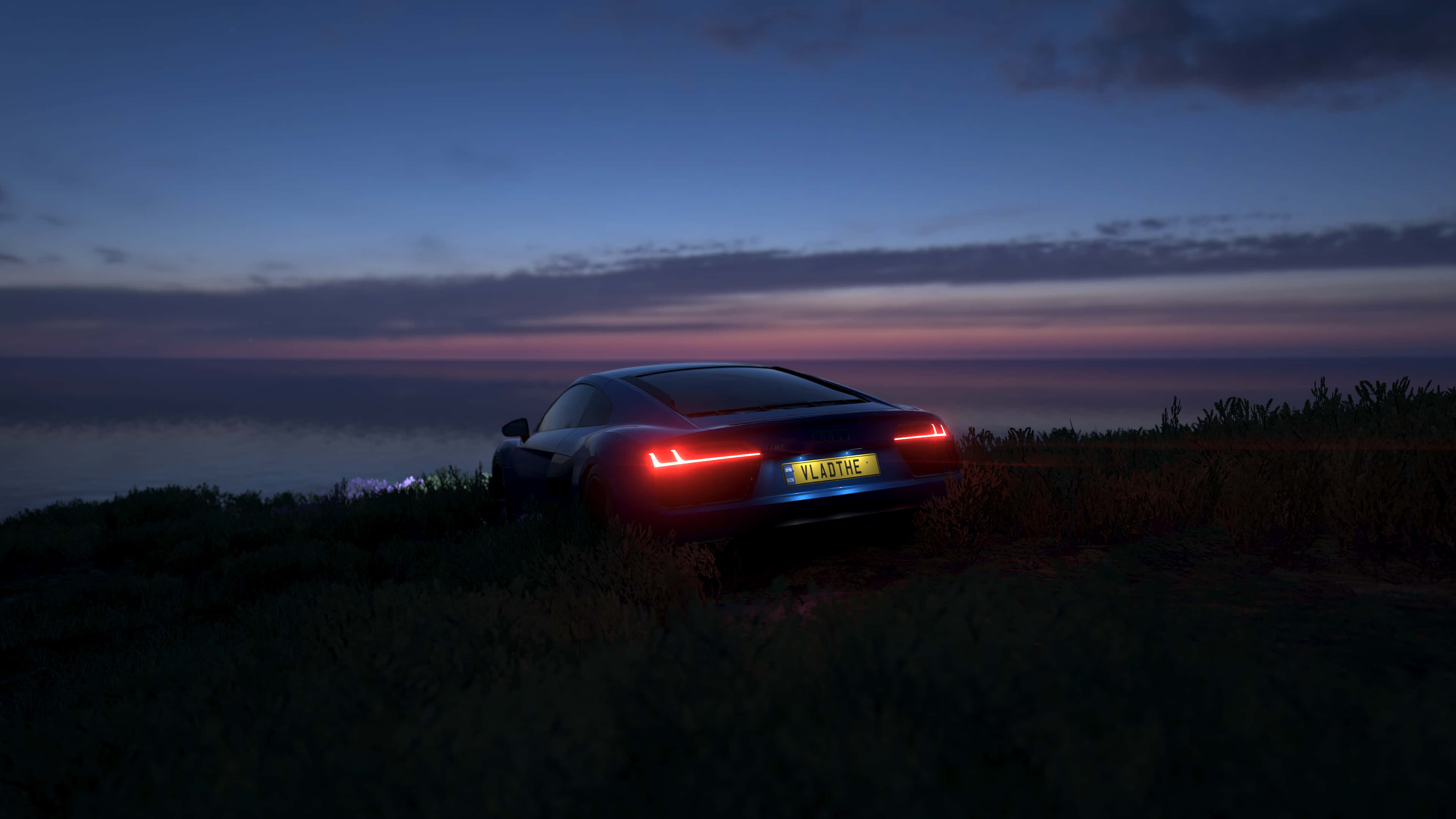 Forza Horizon 4 精彩 4K 行動畫面 壁紙 — 一架時尚黑色跑車帶有發光紅色尾燈，停泊在黃昏時俯瞰海洋的草叢懸崖上。