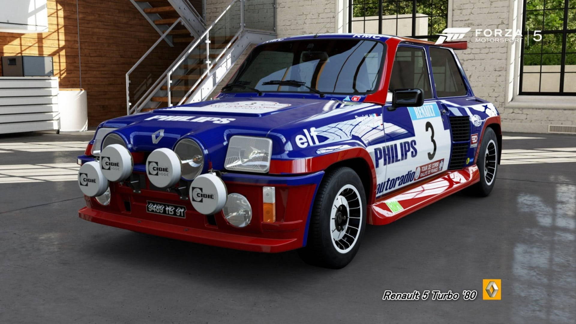 一輛藍、紅、白色的雷諾5 Turbo 1980年拉力賽車在現代車庫中。