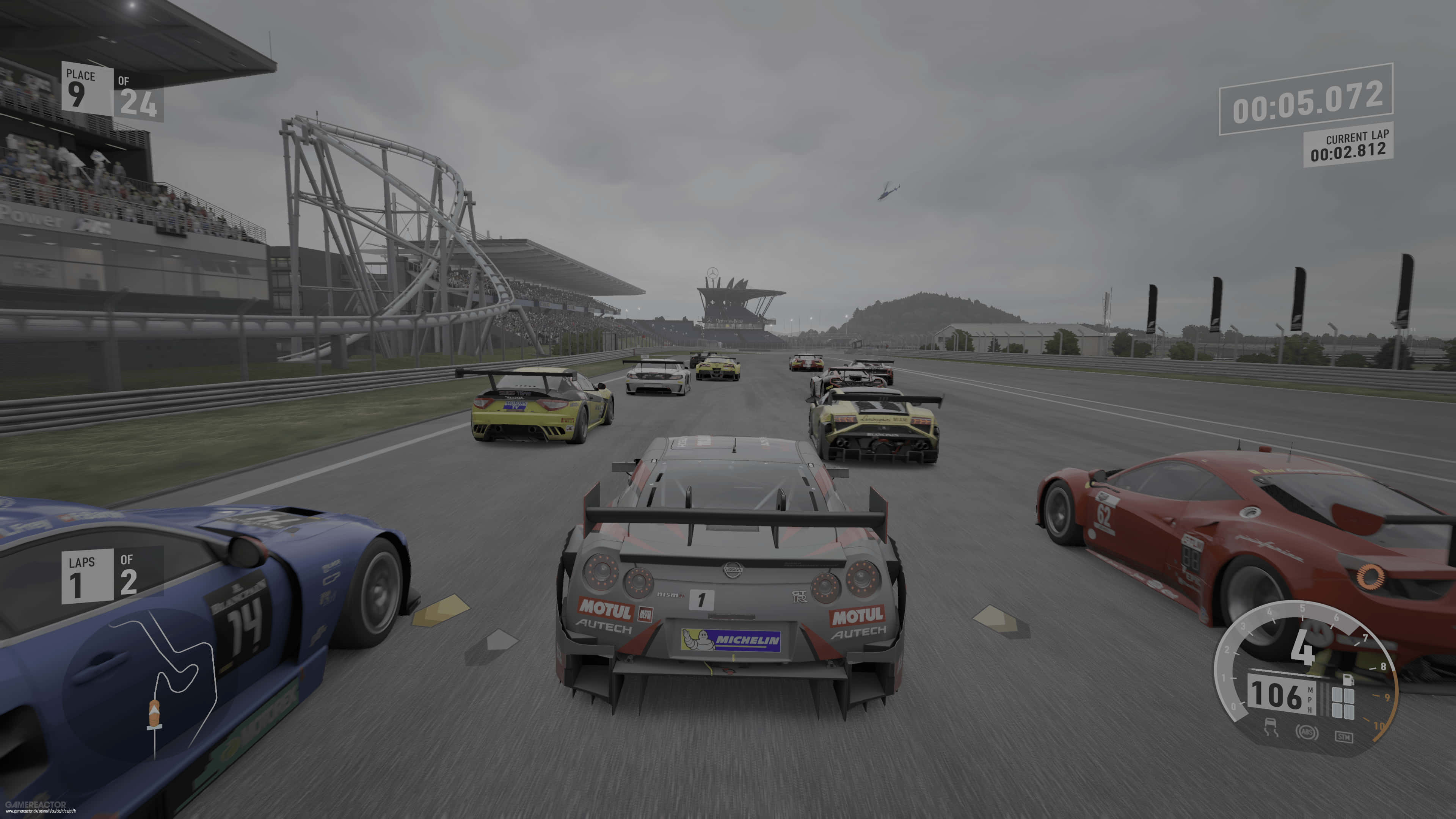感受Forza Motorsport 7的賽車極致快感 壁紙 — 賽車遊戲視角，從灰色賽車後方觀看，在潮濕賽道上與其他賽車和看台一同飛馳，天空多雲。