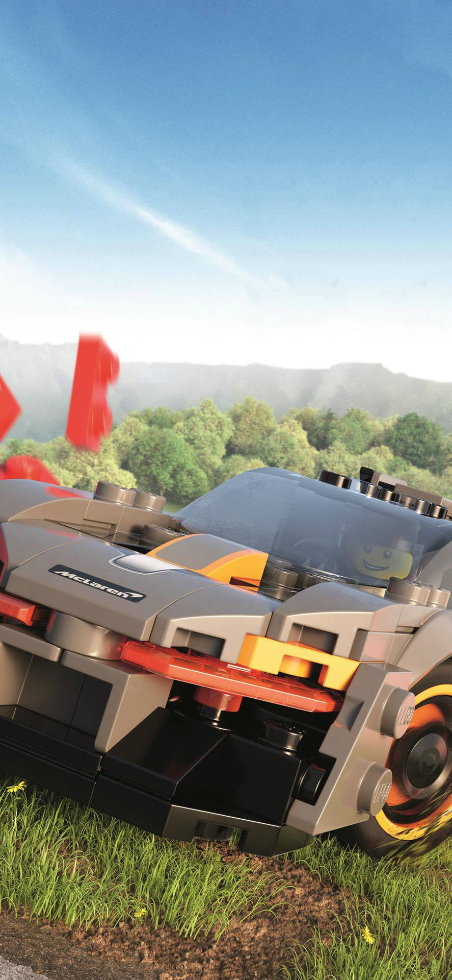 LEGO McLaren賽車停放在草地，靠近樹林覆蓋的山丘，藍天之下