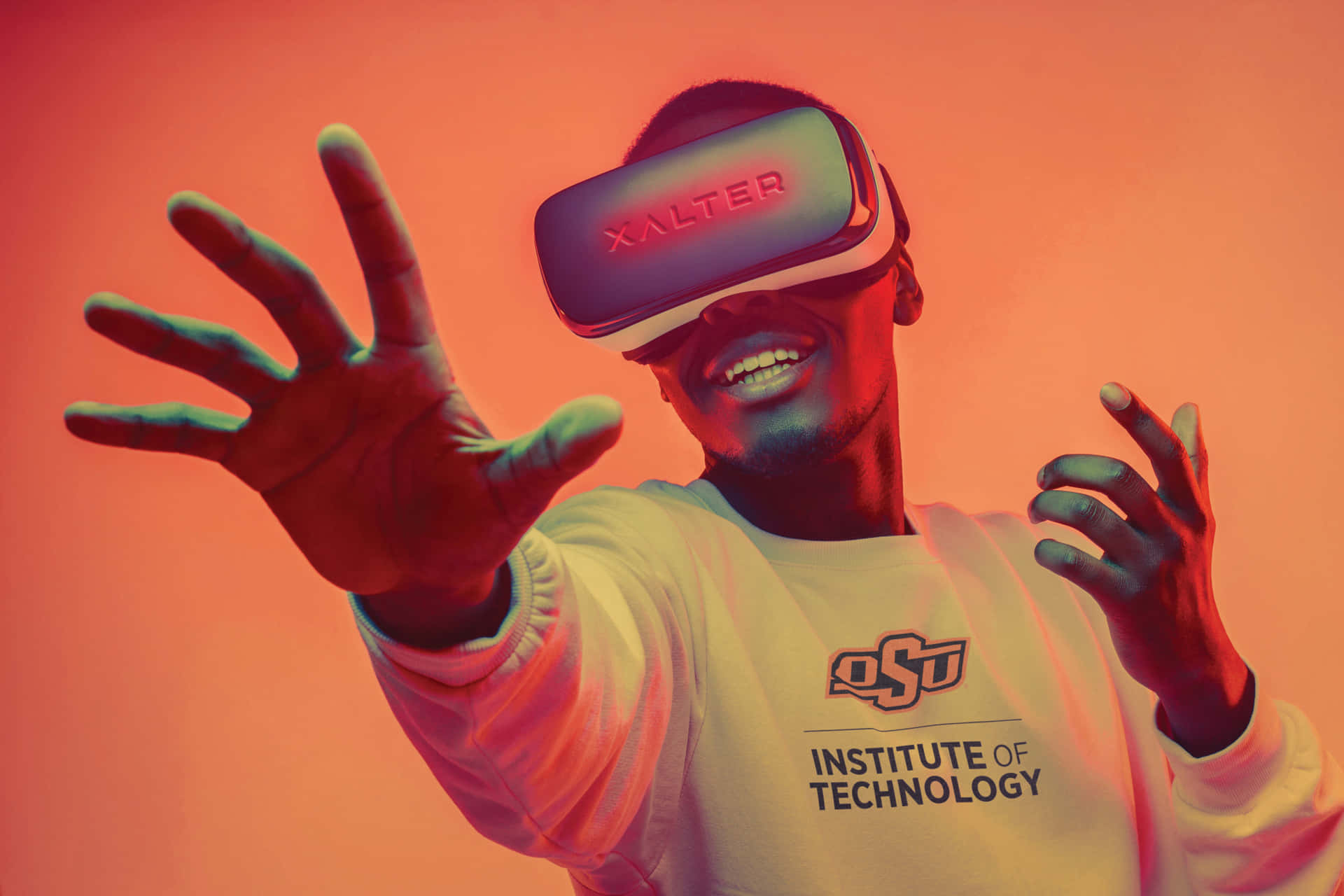 戴著VR頭戴式裝置的人微笑著在彩色光線中伸出雙手。