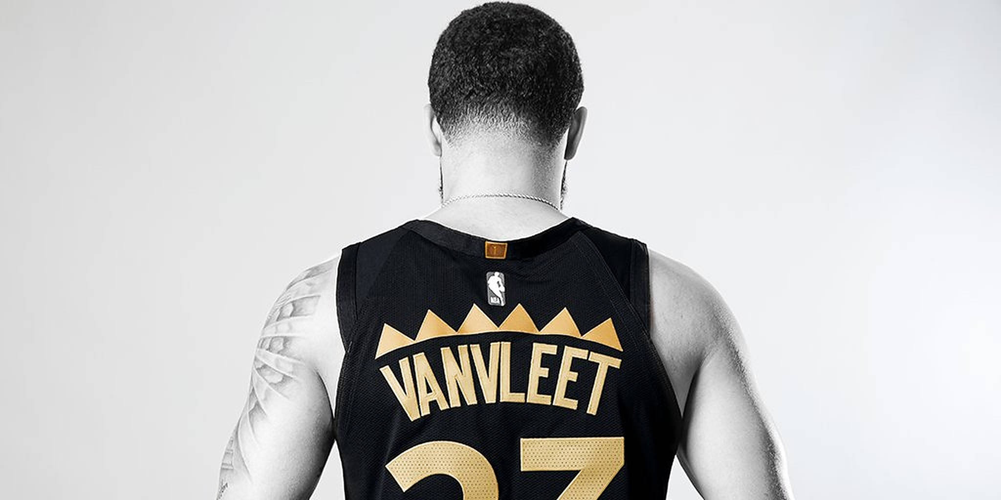 Fred Vanvleet 後視圖 壁紙 — 一名籃球運動員身穿黑色和金色球衣，上面印有「VANVLEET」和27號，背景為純白色，從背面觀看。