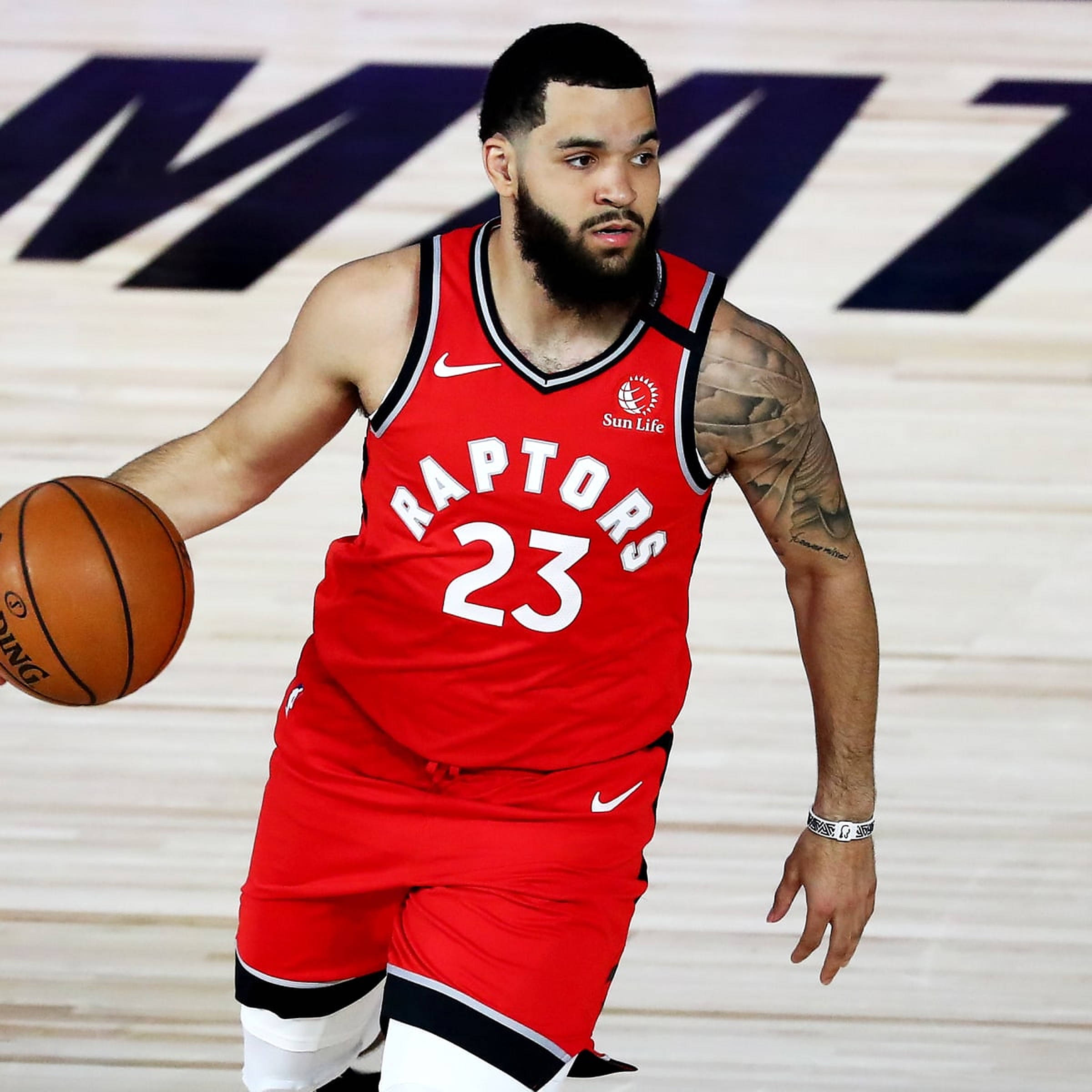 Fred Vanvleet 暴龍隊球員 壁紙 — 一位多倫多速龍隊籃球運動員身穿紅色球衣，在球場上專注地運球。