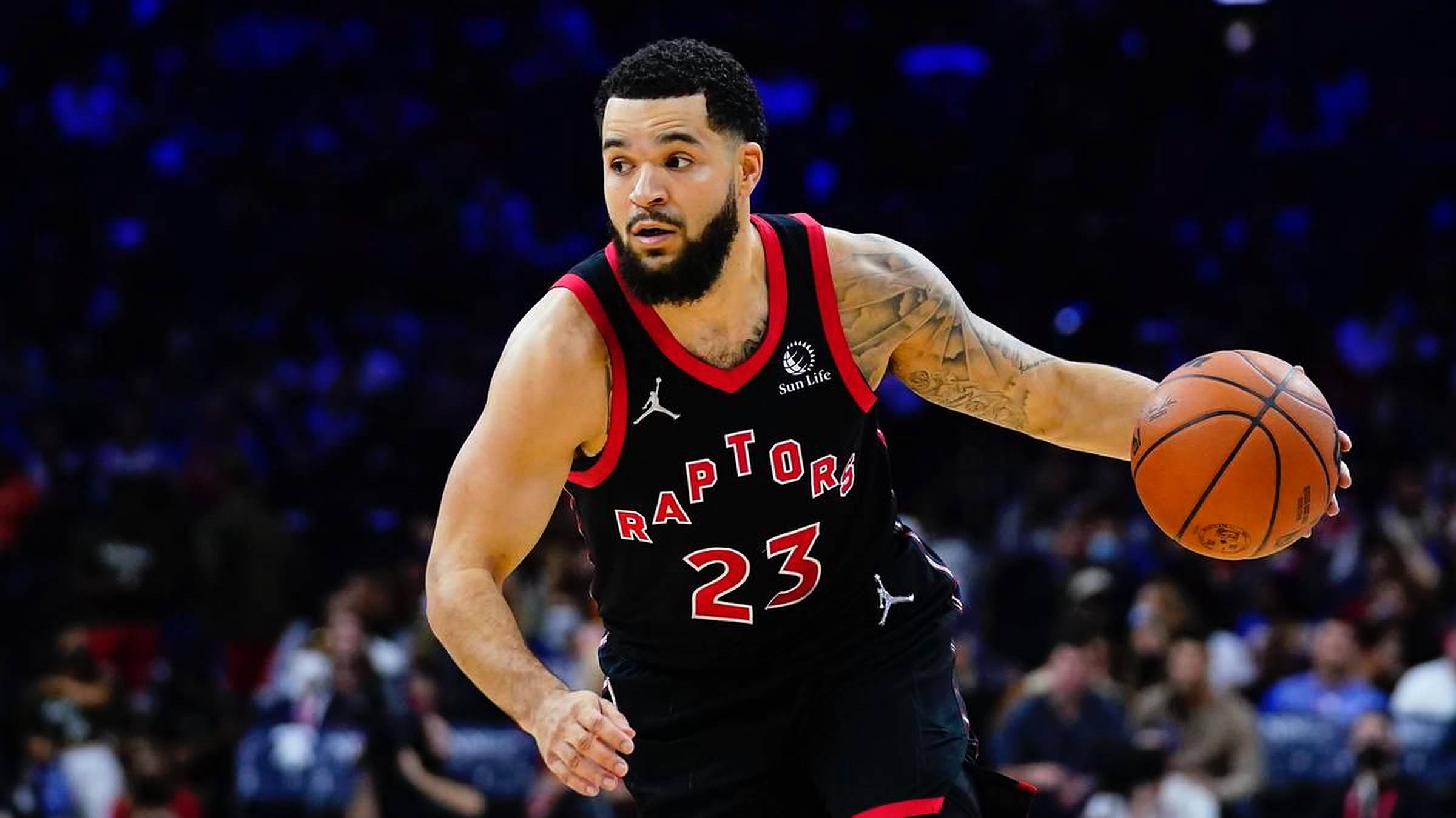 Fred Vanvleet 球員23號 壁紙 — 一位多倫多速龍隊籃球運動員身穿黑紅球衣，在明亮的場館燈光下專注地運球。