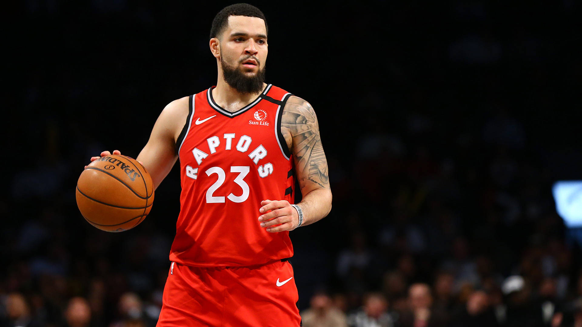 Fred Vanvleet 紅色暴龍隊 壁紙 — 一位多倫多速龍隊籃球運動員身穿紅色23號球衣，在場館燈光下於比賽中運球。