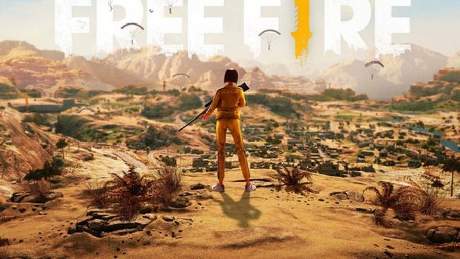 Free Fire 女戰士 Kelly 壁紙 — 一名身穿黃色裝備的玩家站在沙漠山脊上，俯瞰著一片廣闊的荒地，遠處有山脈和正在降落的降落傘。