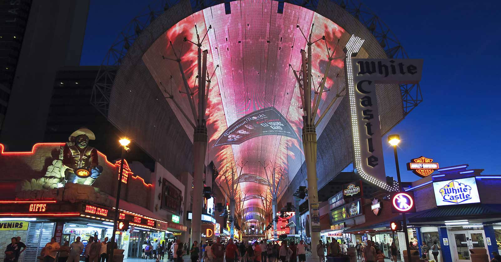 Fremont 街夜景 壁紙 — 充滿活力的霓虹燈在夜晚照亮了拉斯維加斯一條繁忙的街道，上方是發光的粉紅色天篷。