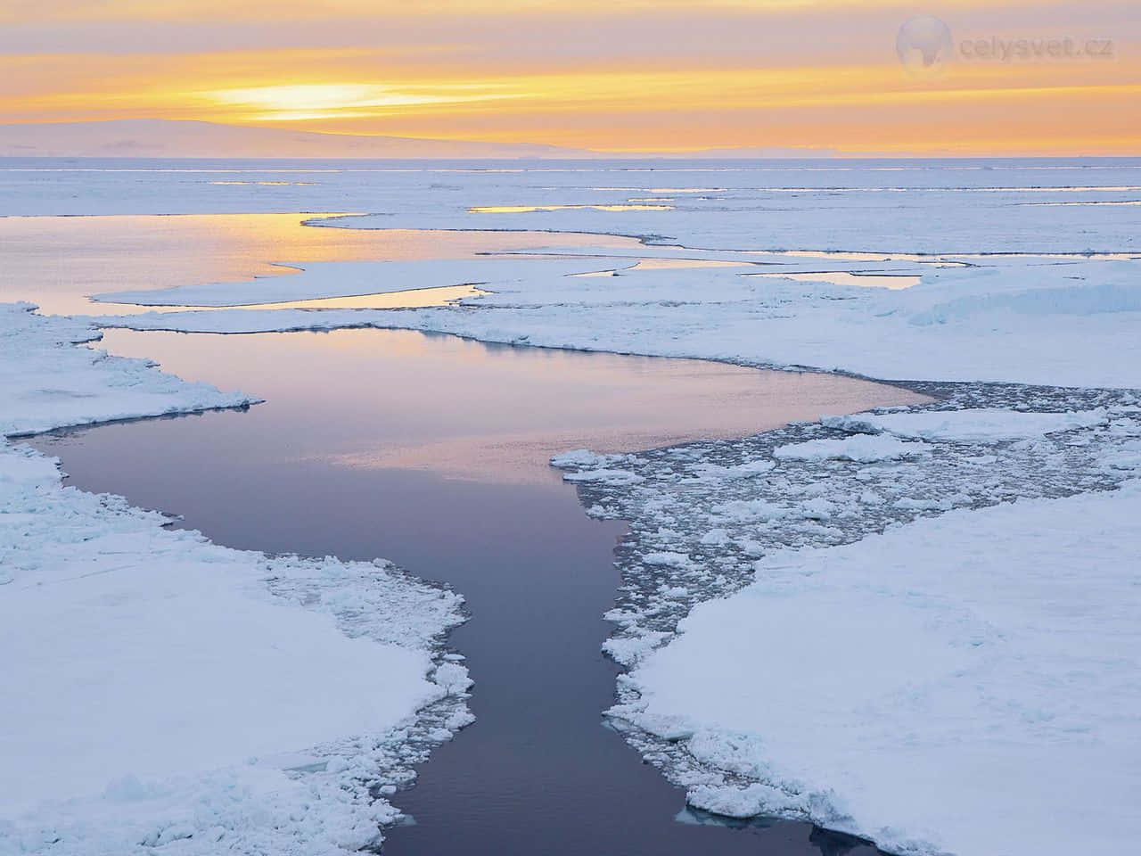 冰封河流蜿蜒穿過雪地凍原，夕陽