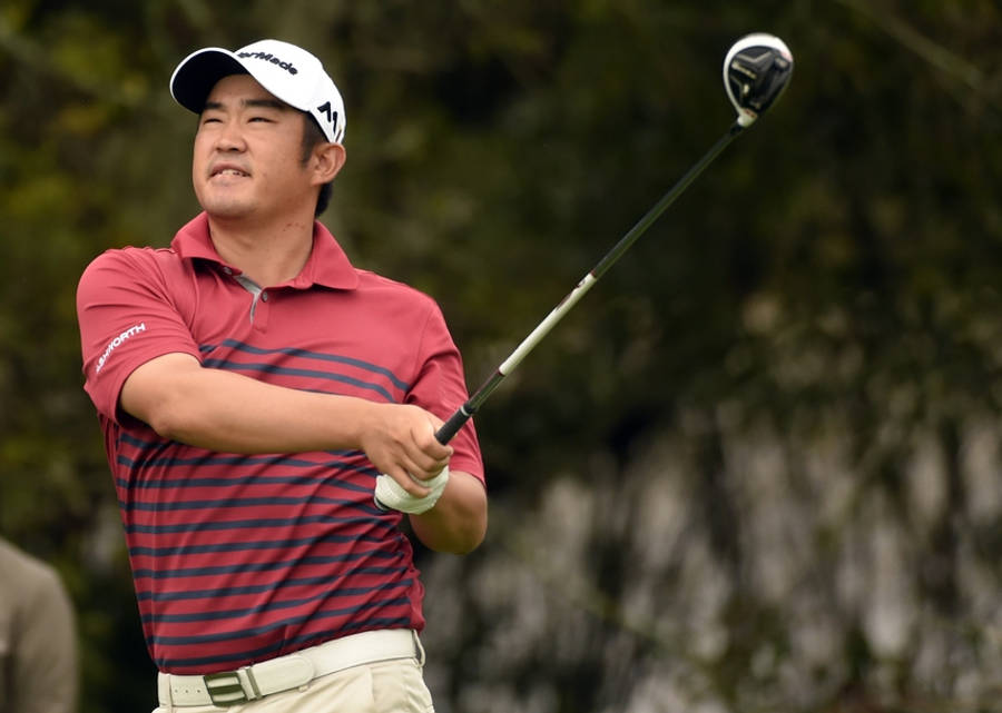 FSU 男子高爾夫賽 John Huh 壁紙 — 一位專注的高爾夫球手正在揮桿，身穿紅色條紋Polo衫和白色帽子，背景是模糊的綠色。