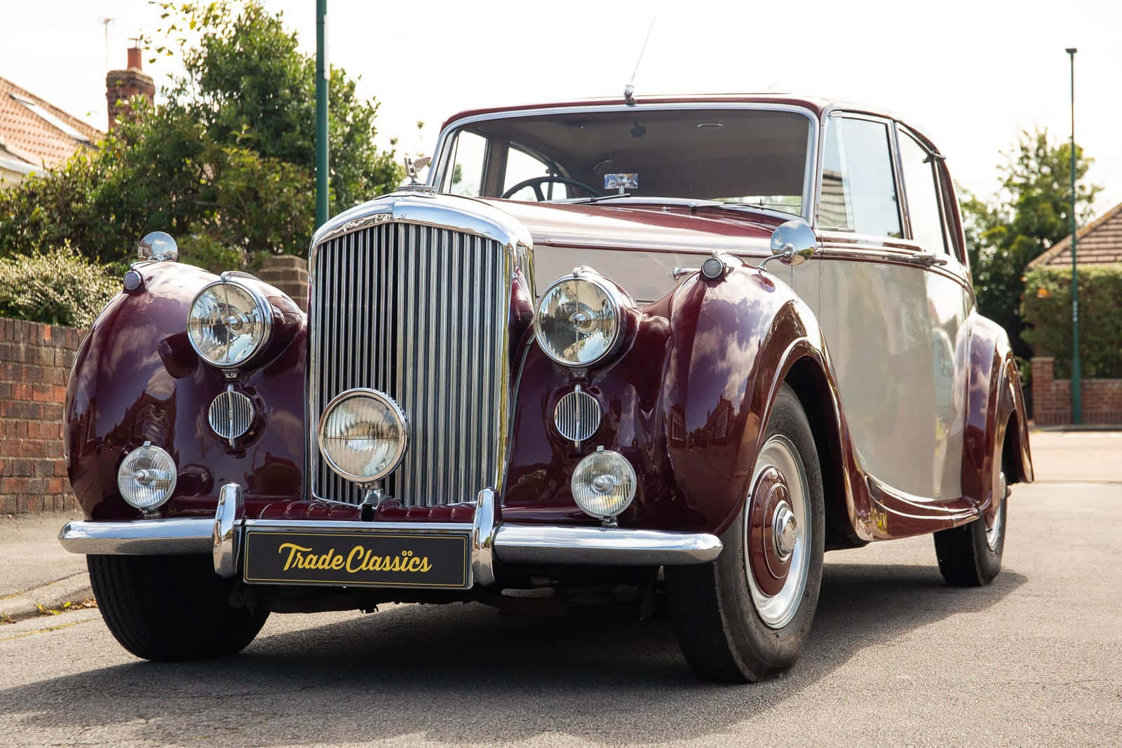 Bentley Mark Vi 桌布 壁紙 — 一輛復古酒紅色和奶油色的經典汽車，帶有鍍鉻格柵和圓形頭燈，停在住宅街道上。