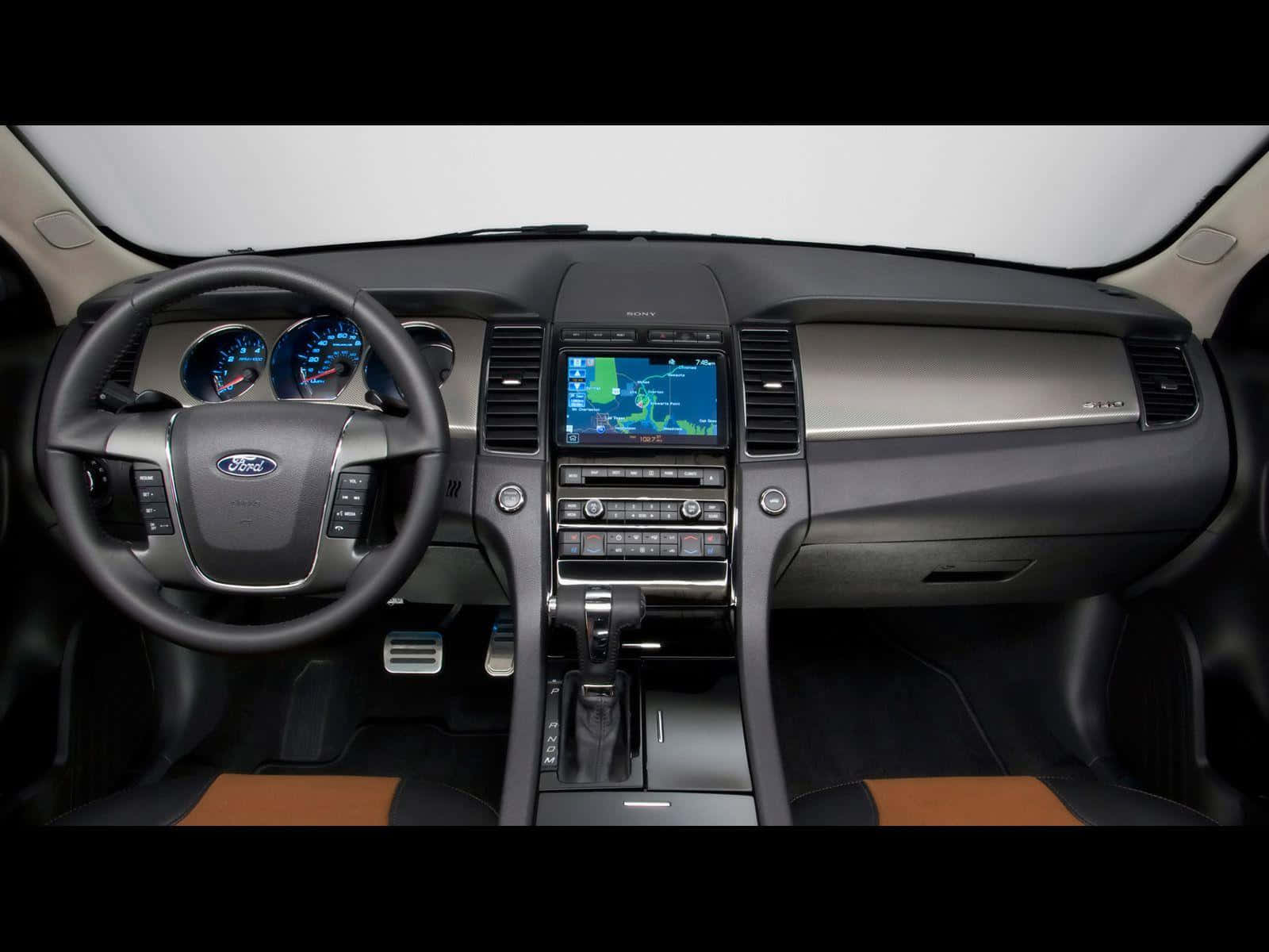 Ford Taurus 桌布 壁紙 — 福特汽車儀表板內部視圖，帶有發光藍色儀表和導航屏幕。