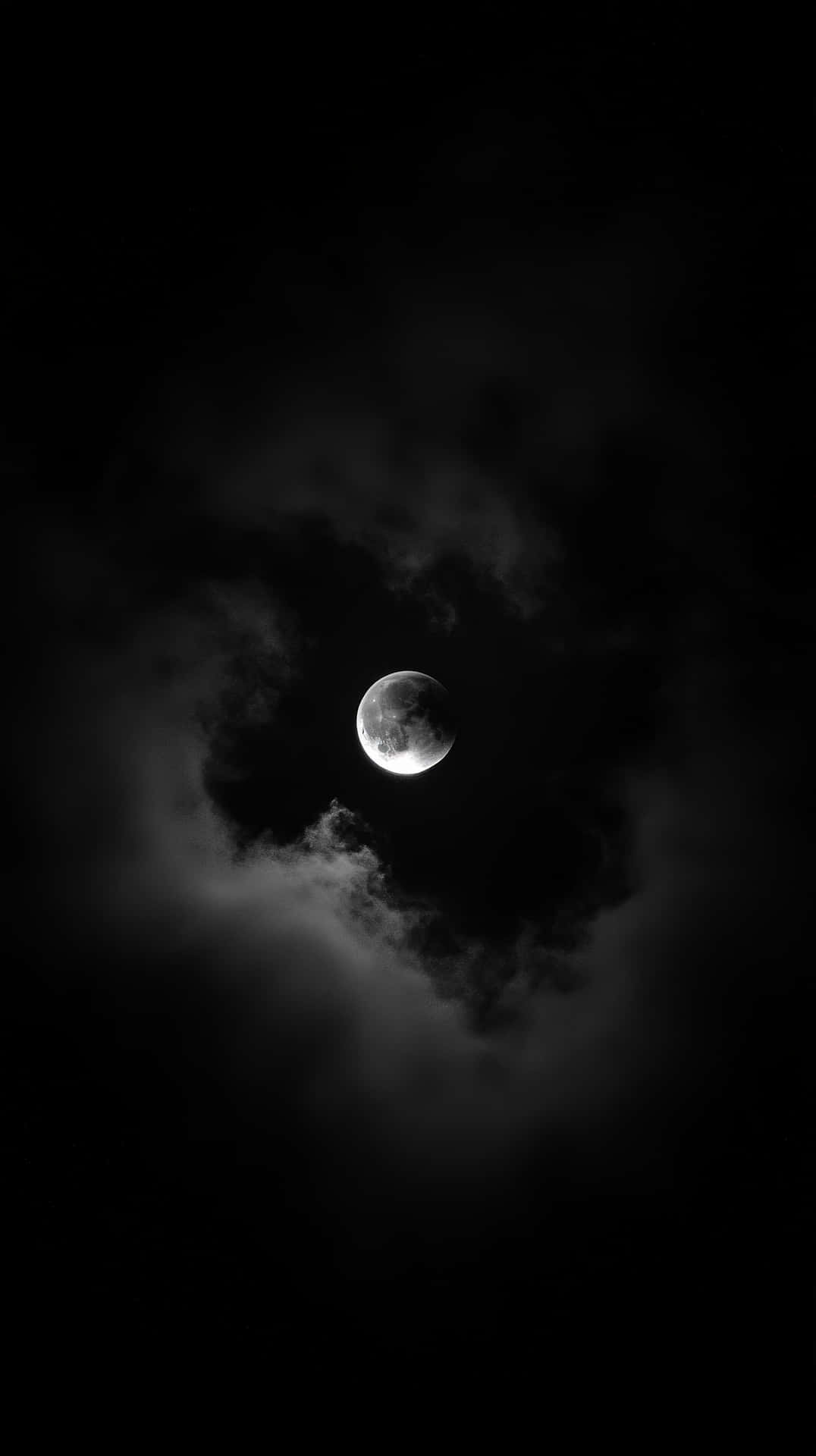 明亮的彎月被烏雲環繞，黑色天空