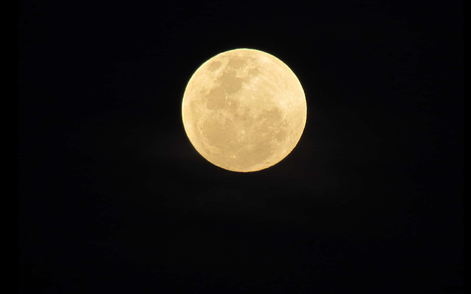 滿月在黑暗的夜空中閃耀，帶有微妙的雲彩。