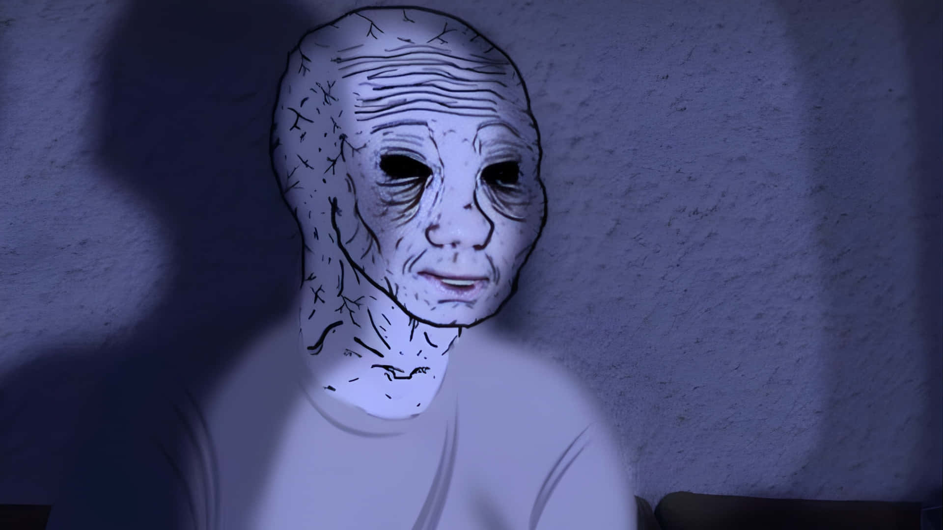  壁紙 — 一個縫合皮膚、空洞眼睛的駭人面孔，在昏暗藍光下對著紋理牆壁發光。