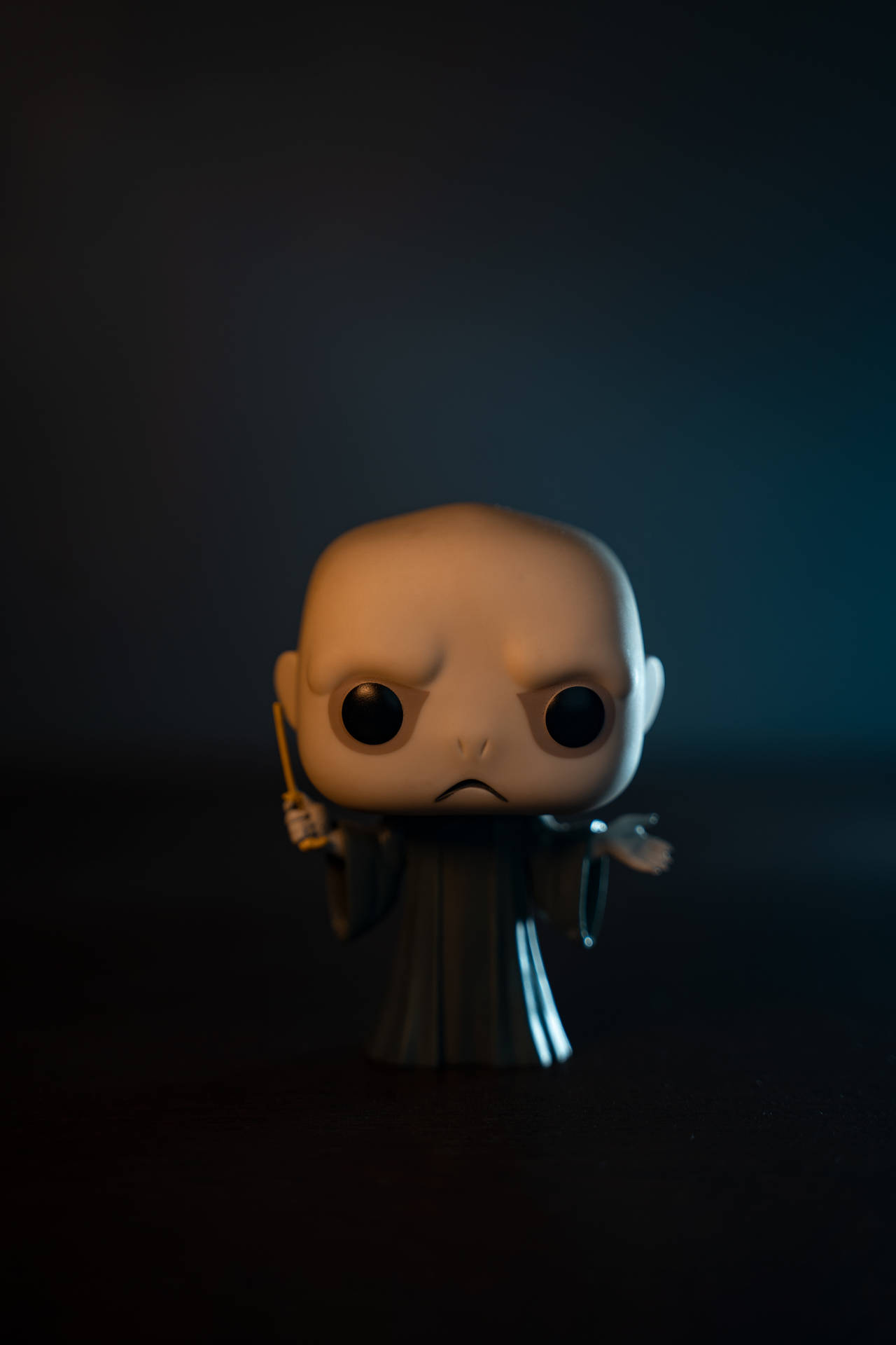在暗淡燈光下手持魔杖的Funko Pop佛地魔公仔。