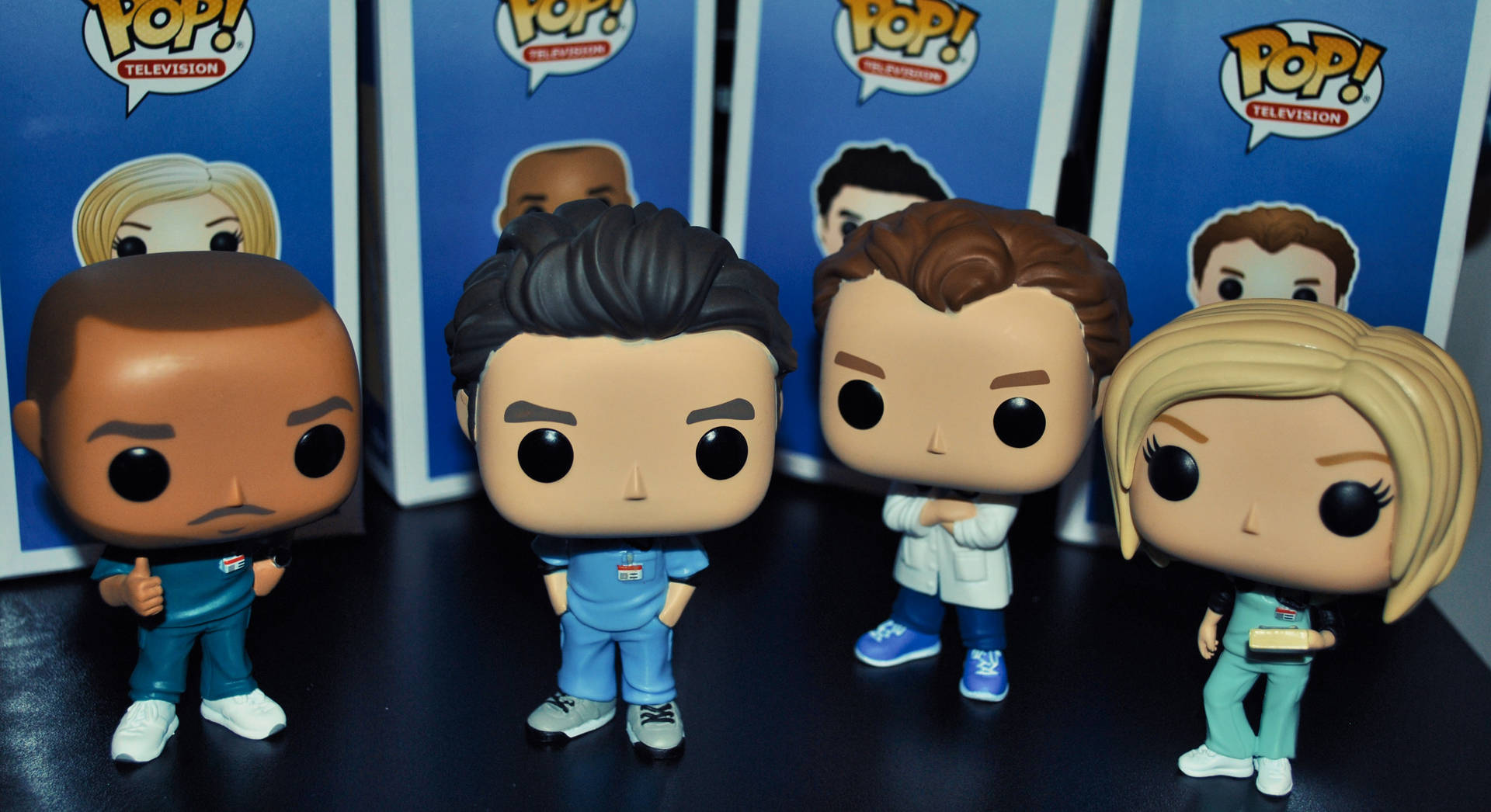 四個穿著醫療人員服裝的 Funko Pop! TV 人偶在深色表面上擺姿勢。