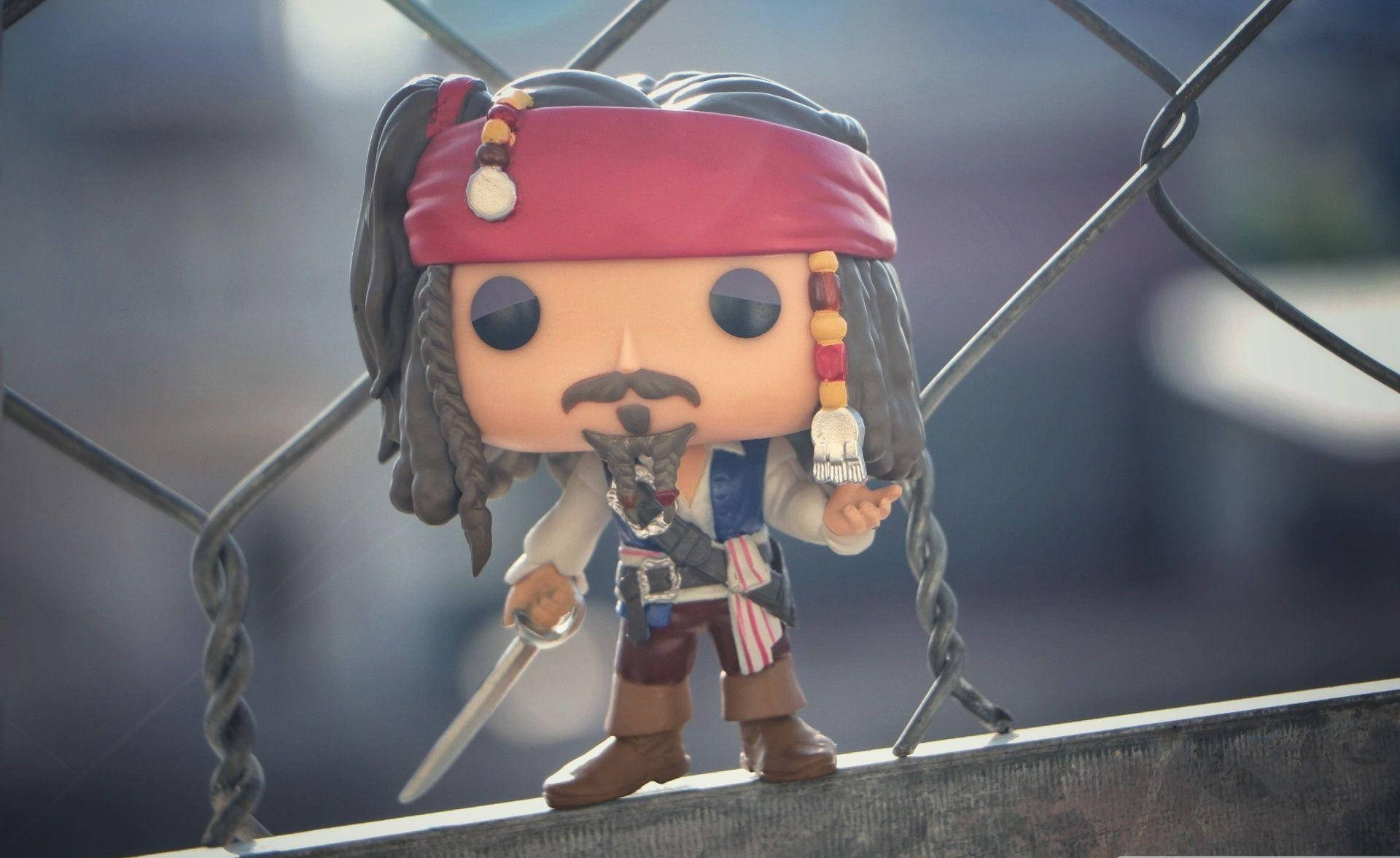 Funko Pop 杰克·史派羅 壁紙 — 一個Jack Sparrow的Funko Pop公仔站在金屬欄杆上，手持劍。