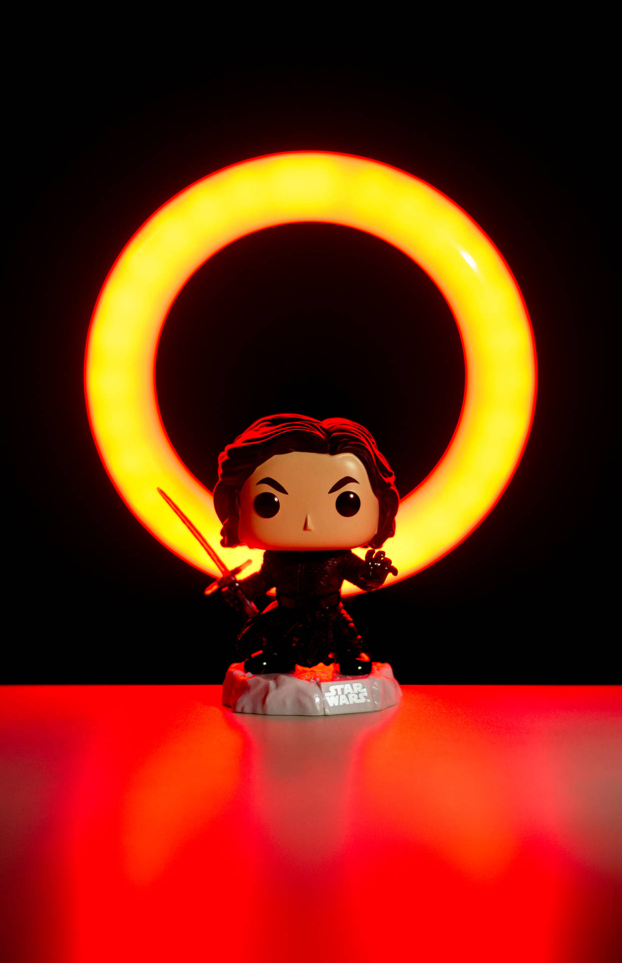 Kylo Ren Funko Pop人偶被發光的橙色環照亮，背景為黑色。
