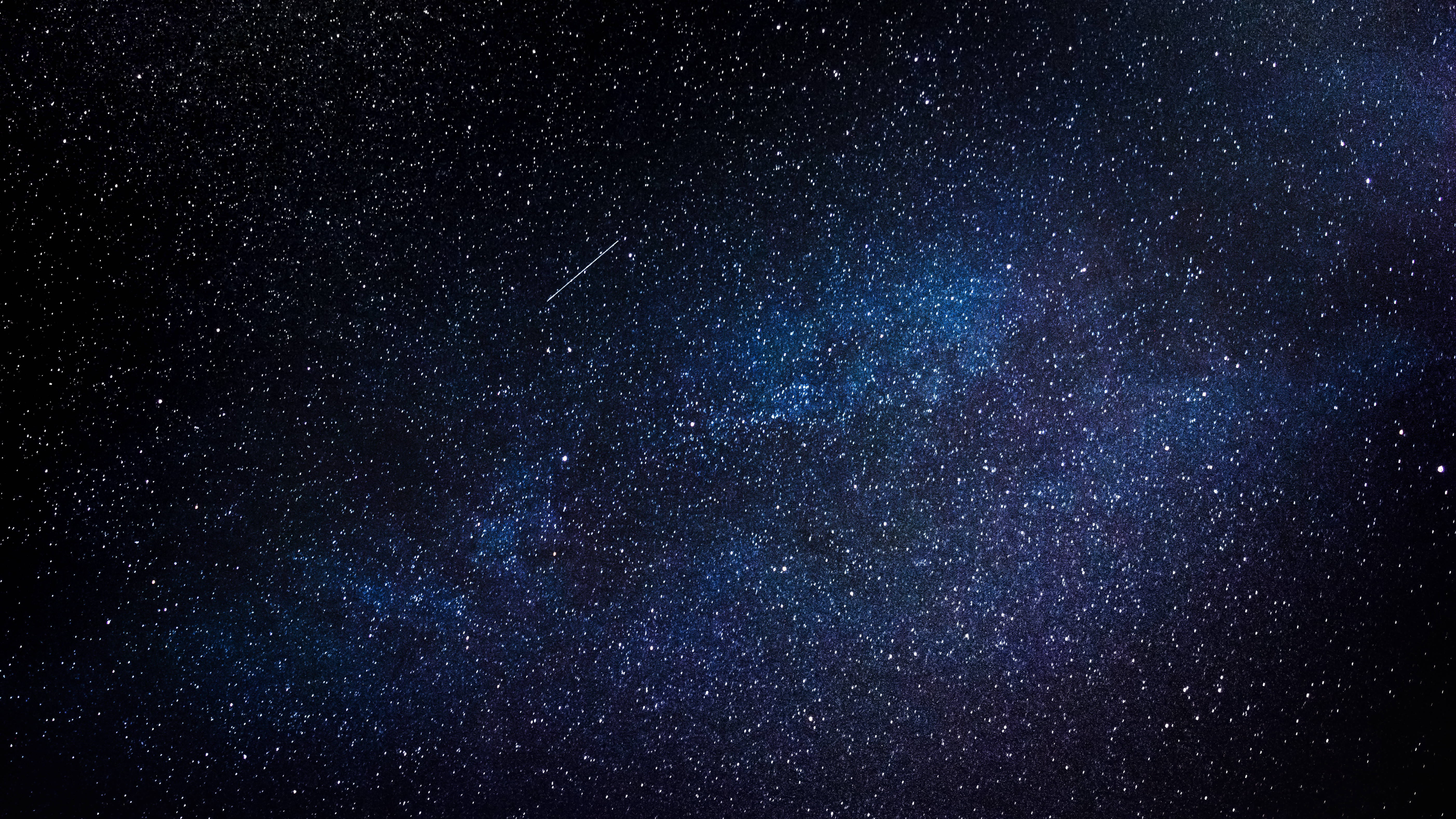 三星 Galaxy S10 Plus 迷人近鏡，展示其鮮豔 AMOLED 屏幕 壁紙 — 令人嘆為觀止的銀河系景觀，在深藍色中閃耀，背景是繁星點點的夜空，一顆微弱的流星劃過天際。