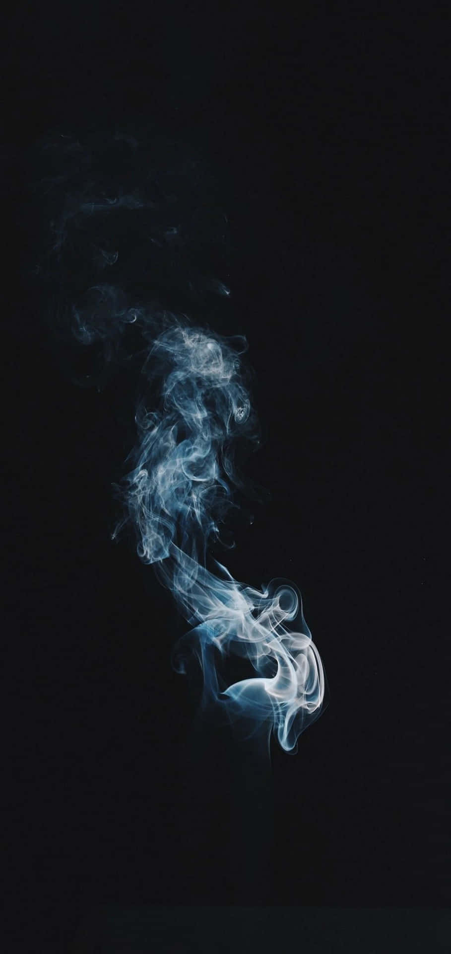 淡藍色煙霧在黑暗中向上飄散