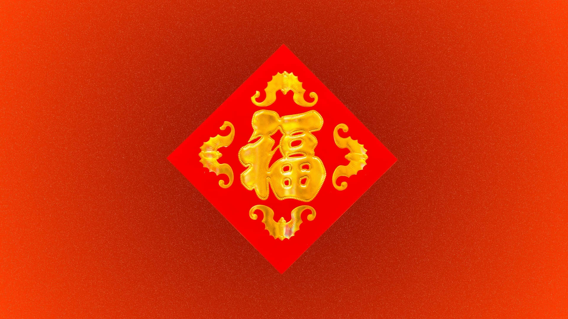  壁紙 — 金色嘅中文字「福」喺有紋理嘅紅色背景上嘅紅色菱形紙上發光。