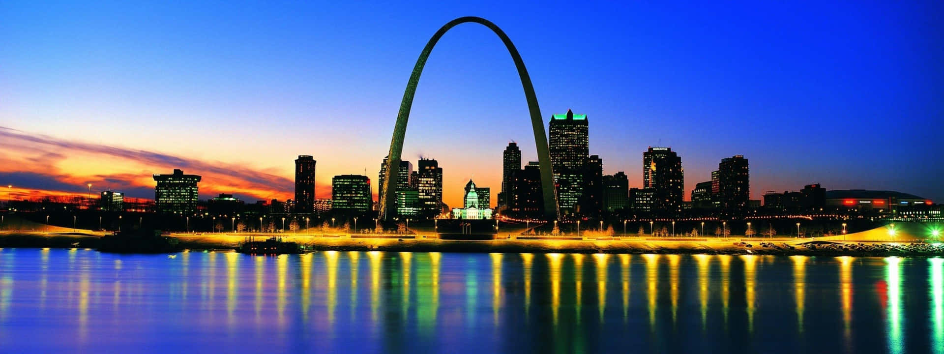 暮色中倒映在河上的 Gateway Arch 和城市天際線。