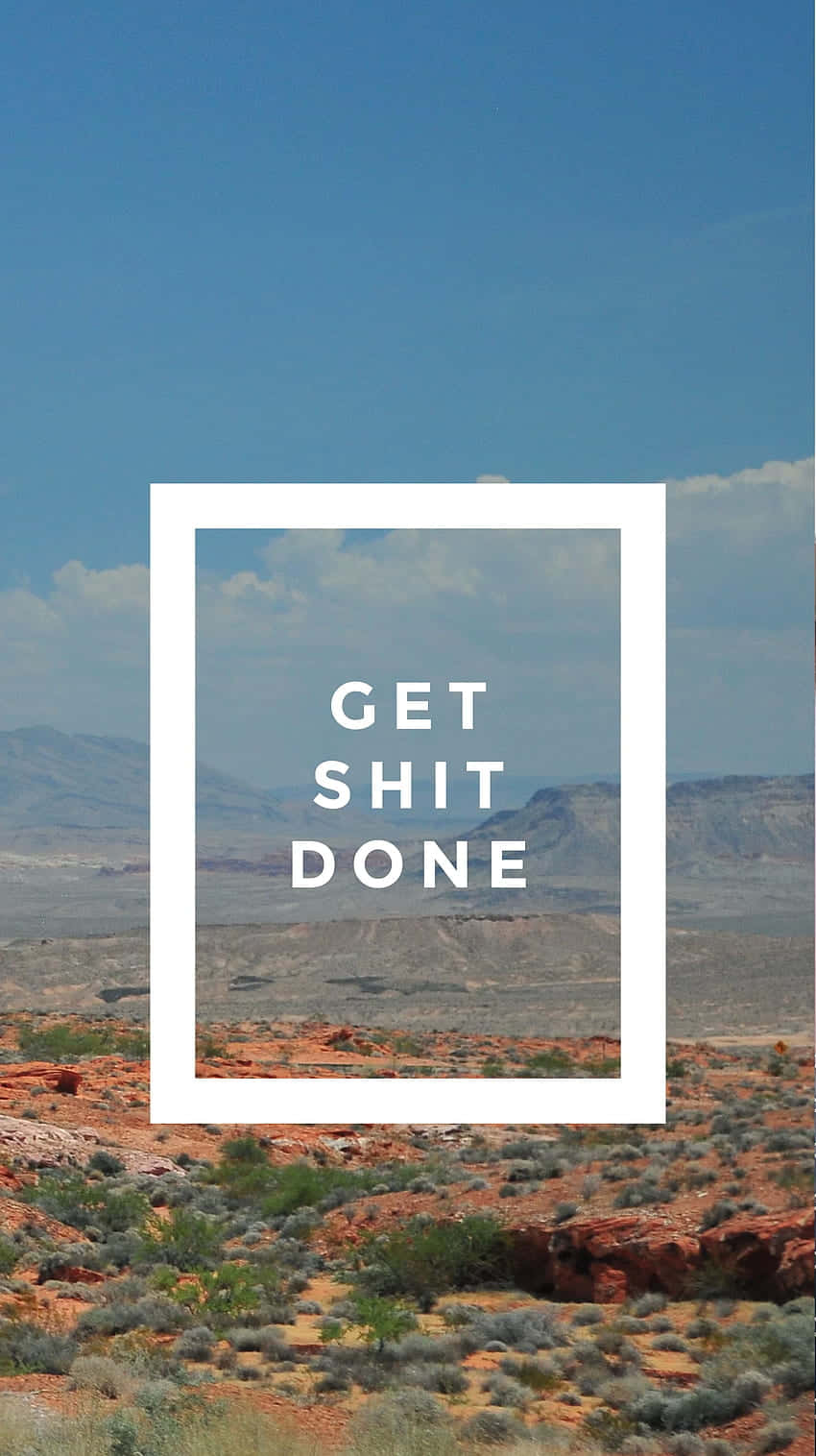 「Get Shit Done」配山景背景 壁紙 — 紅色岩石地貌和稀疏綠色灌木，在藍天白雲下的沙漠景觀。