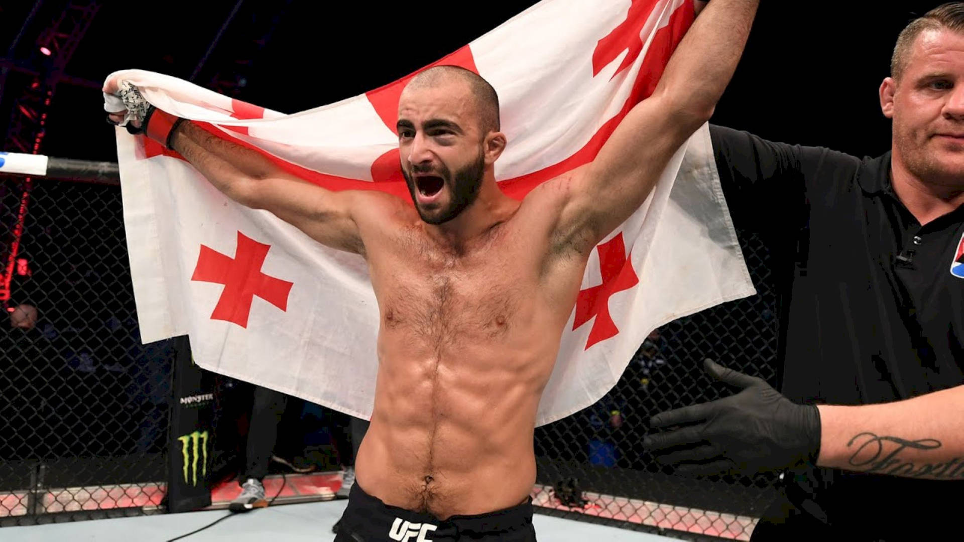UFC拳手在八角籠中手持格魯吉亞旗幟慶祝勝利。