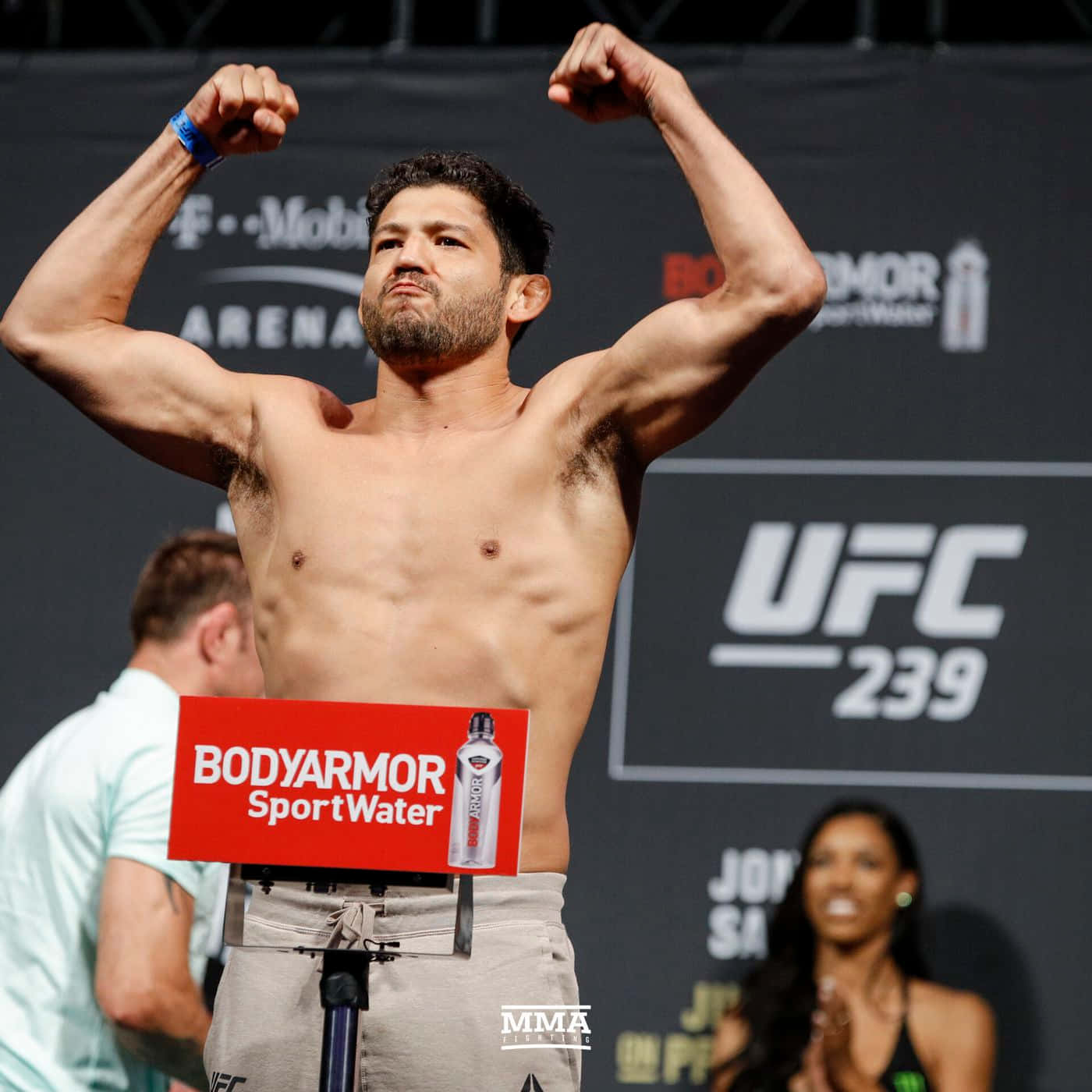 Gilbert Melendez UFC 239體重秤亮相 壁紙 — 一位肌肉發達的UFC拳手在稱重活動中在磅秤上彎曲手臂，背後有BodyArmor標誌和UFC 239品牌。