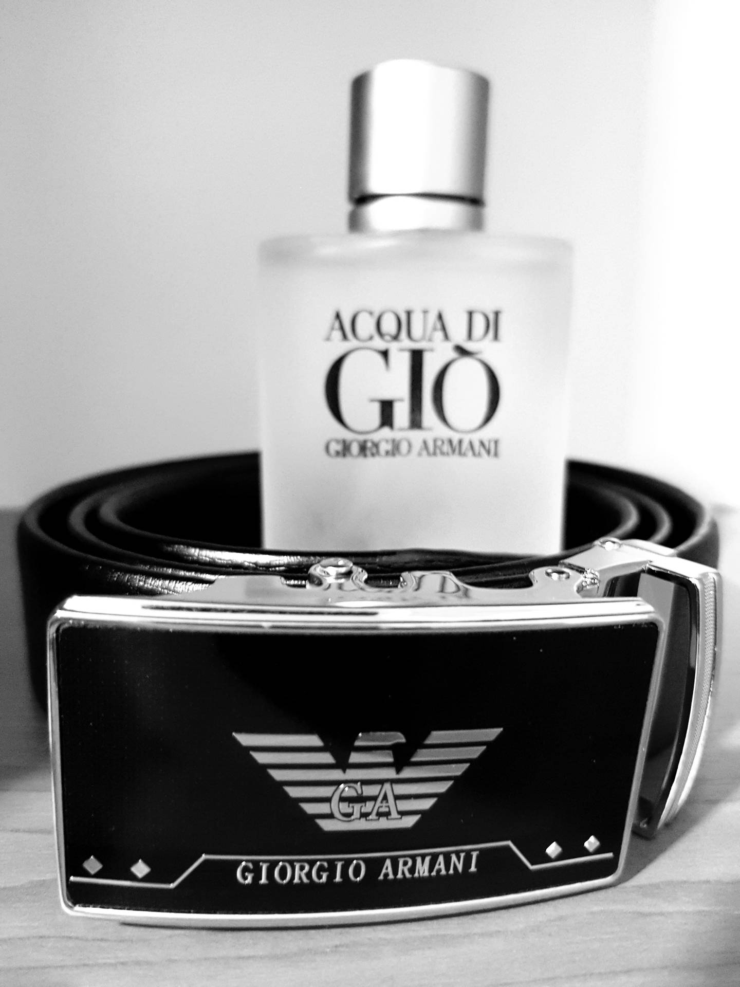 單色調的 Giorgio Armani 皮帶和 Acqua di Gio 香水瓶。