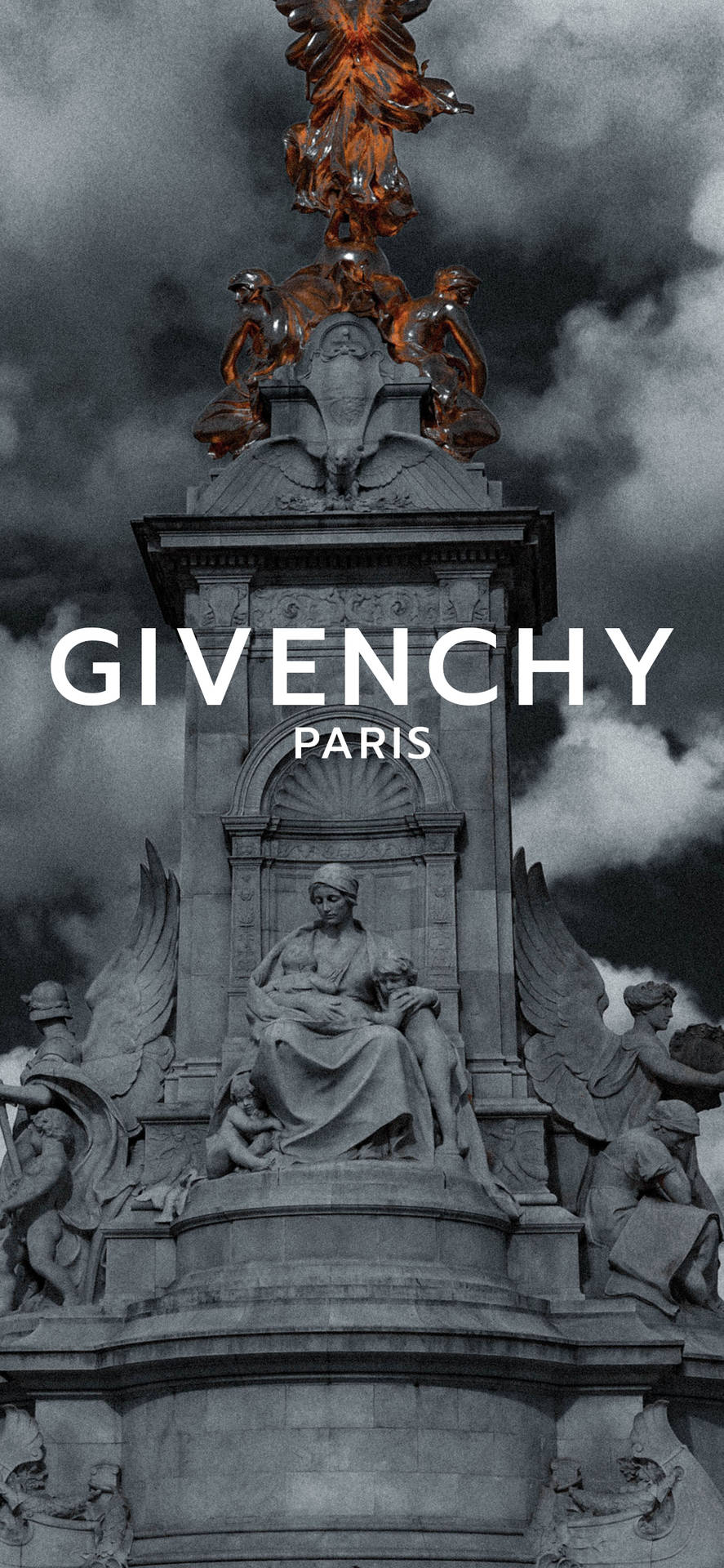 Giverny Paris 紀念碑，在暴風雨天空下，有石雕和金色天使。