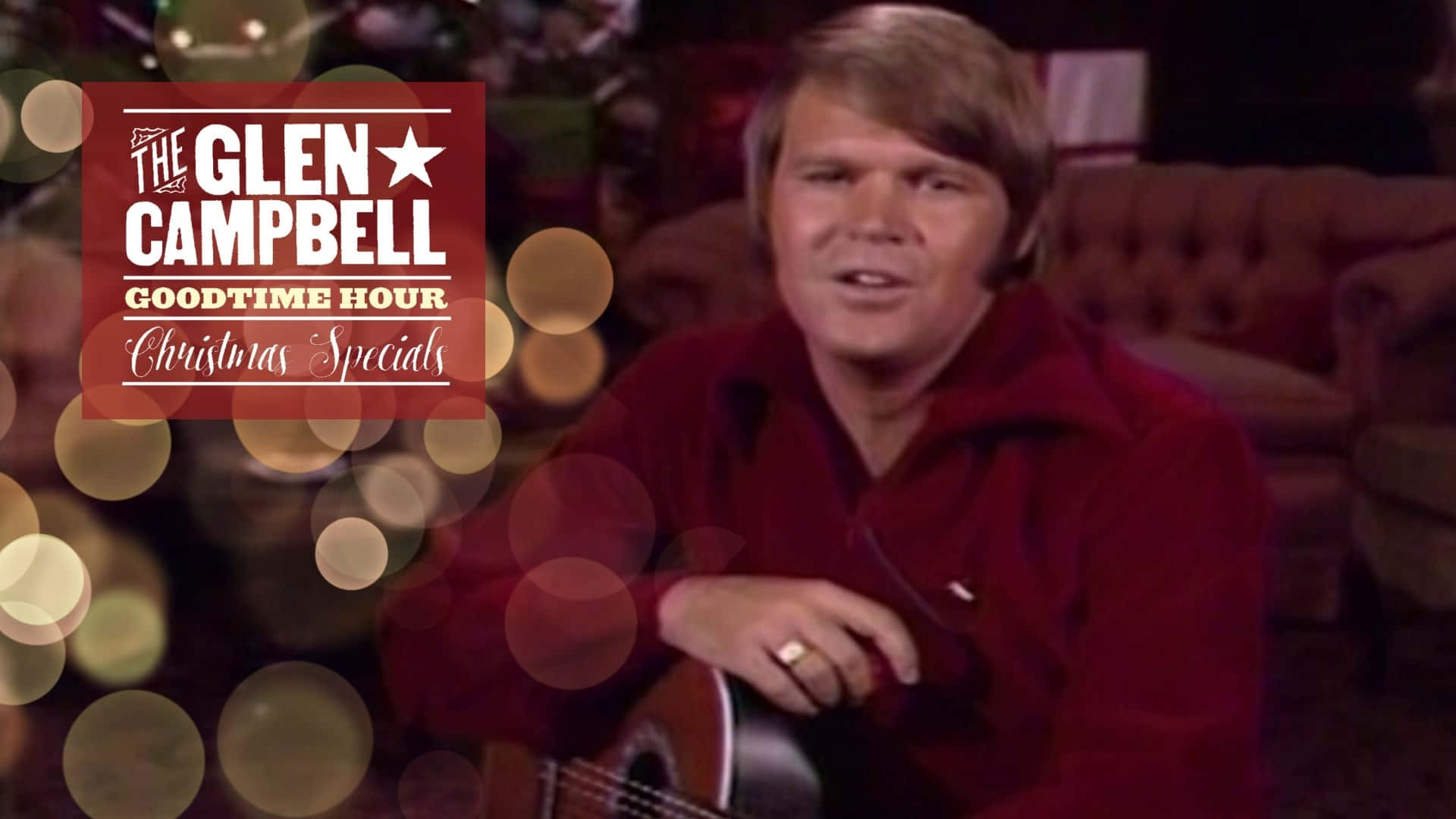  壁紙 — Glen Campbell 穿著紅色襯衫，手持結他，背景有節日散景燈光和聖誕特輯標誌。