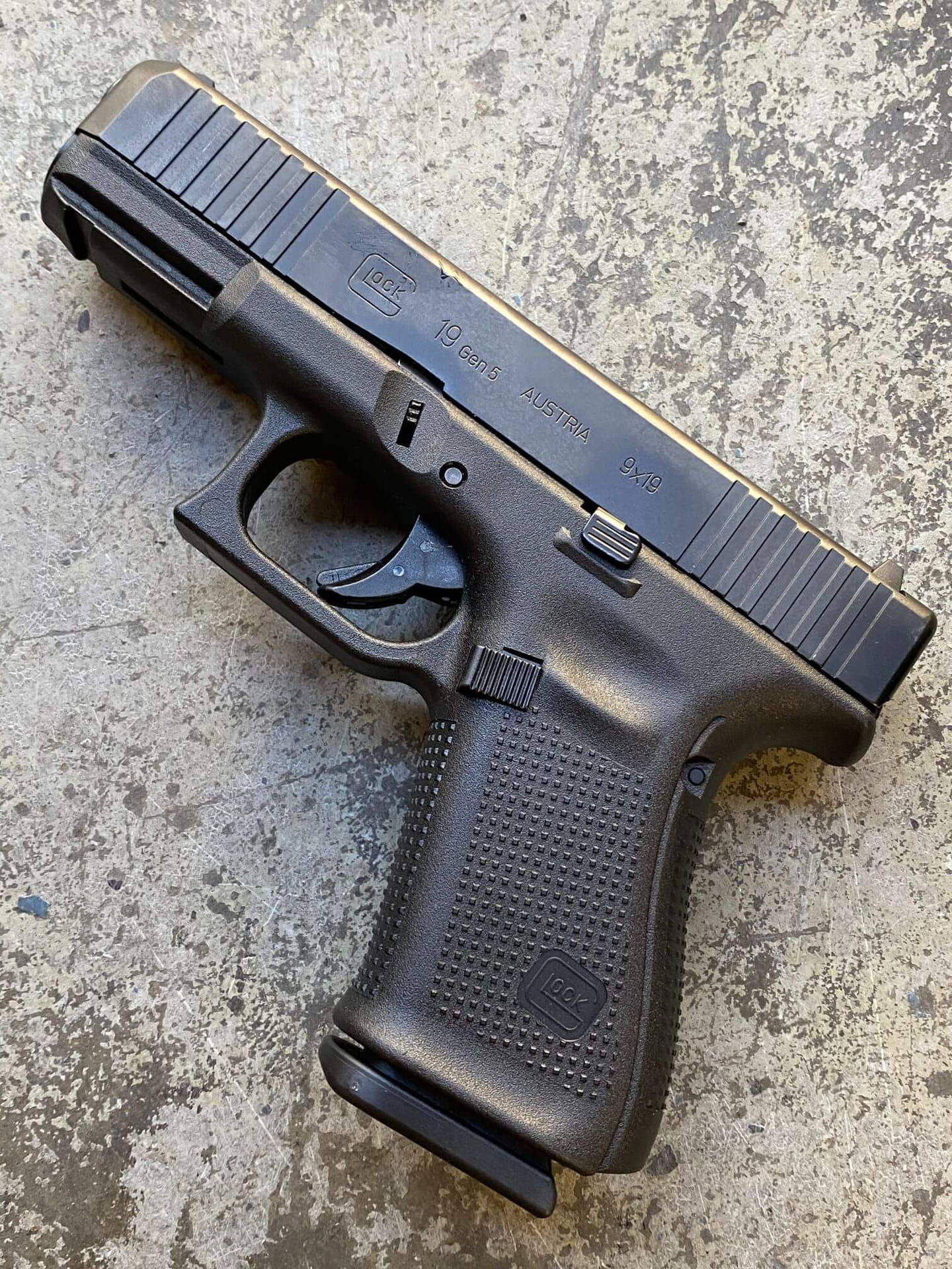 黑色Glock 19 Gen5手槍在紋理混凝土表面上。
