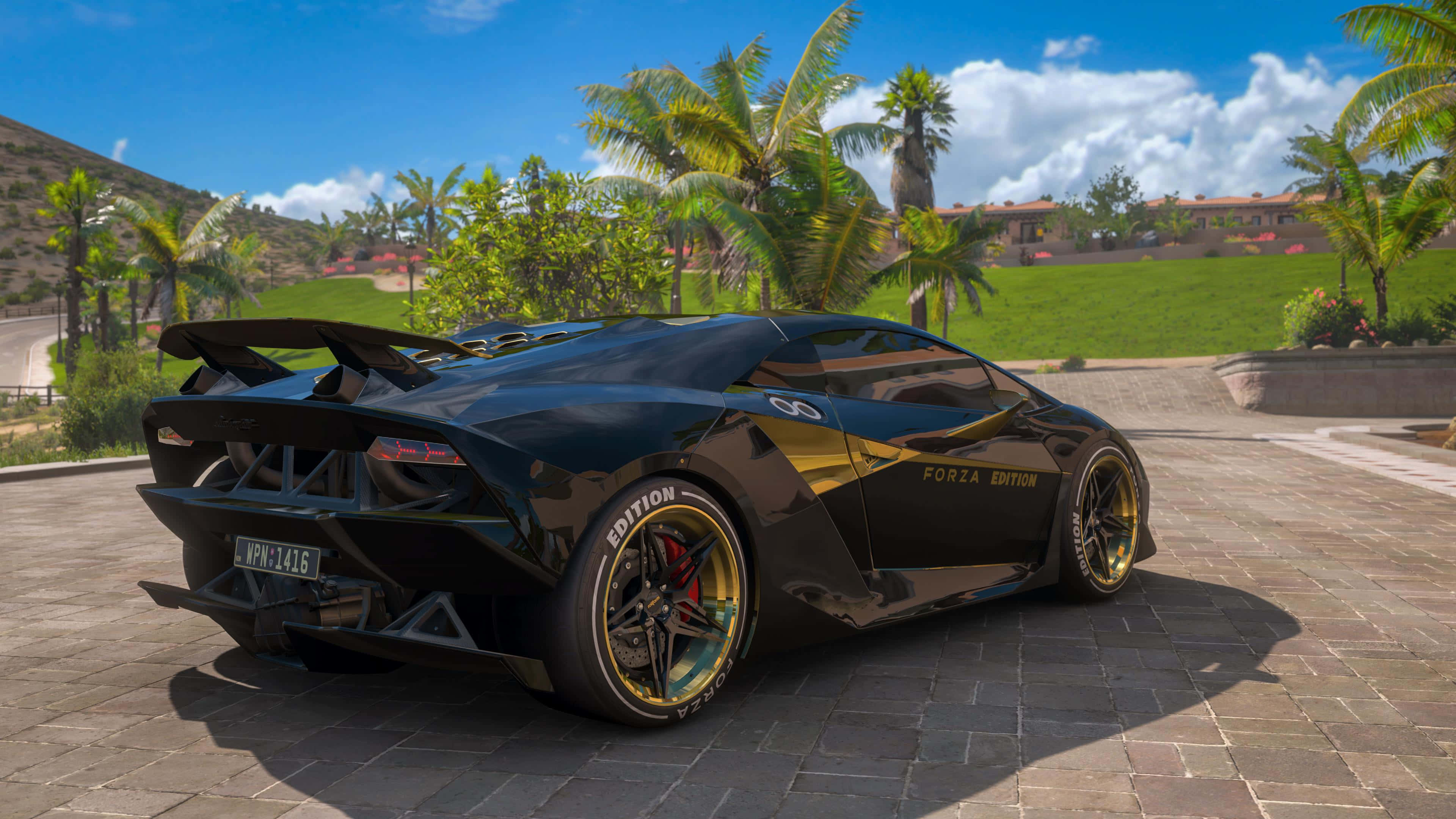 Lamborghini Sesto Elemento 桌布 壁紙 — 一輛帶有金色裝飾和Forza Edition貼紙的亮黑色林寶堅尼，停泊在石頭車道上，上方是藍天和棕櫚樹。